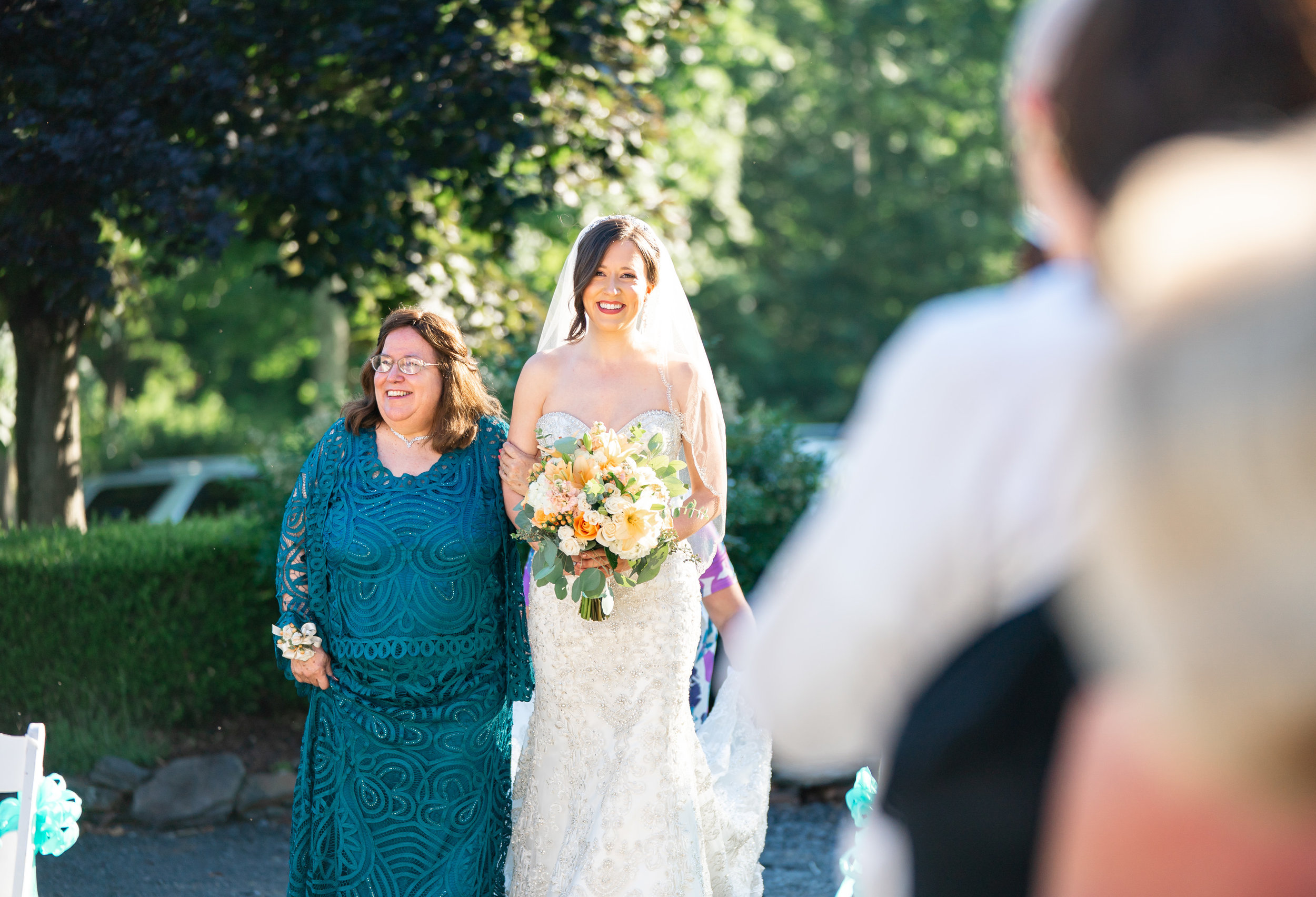 Bride walking down the aisle in front of Harvest House at Lost Creek Winery wedding