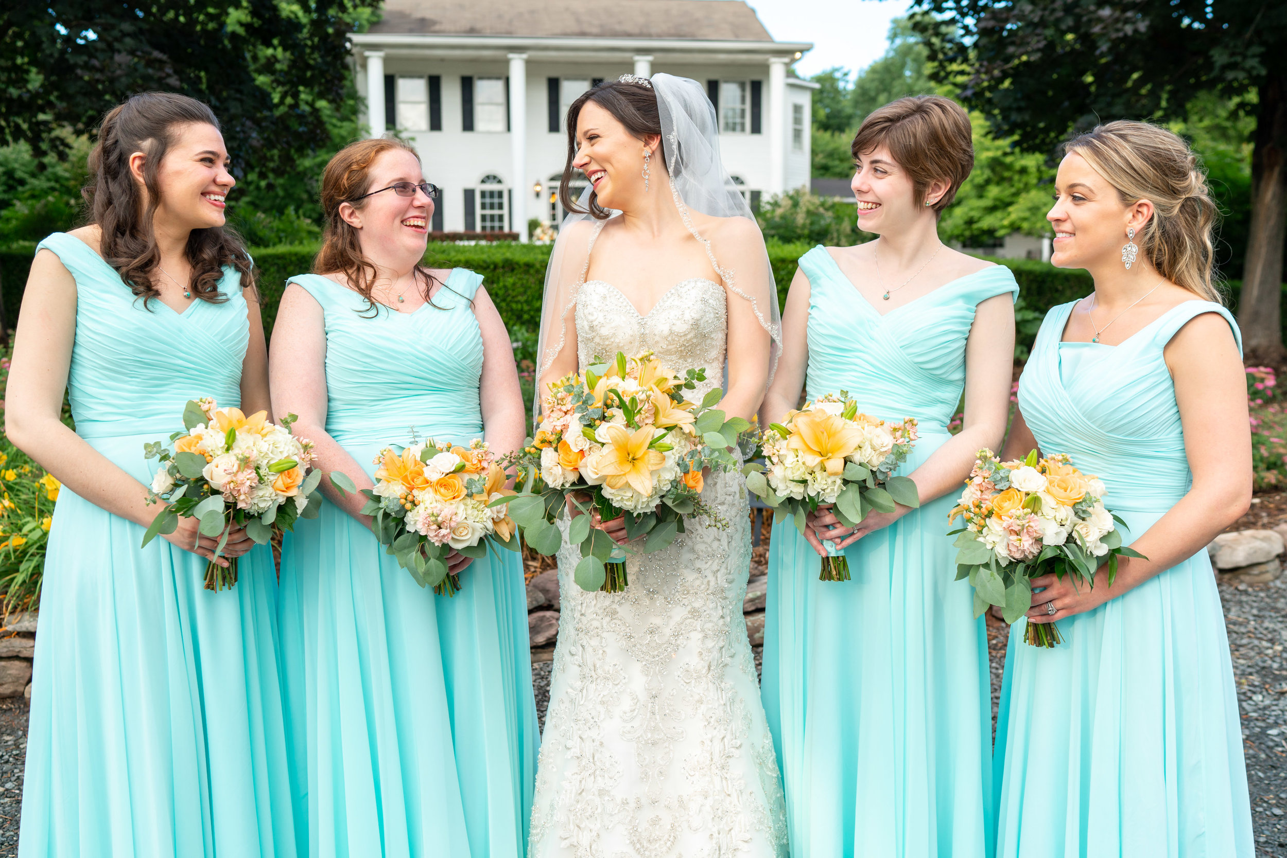 Bride and wedding party in front of Harvest House mansion