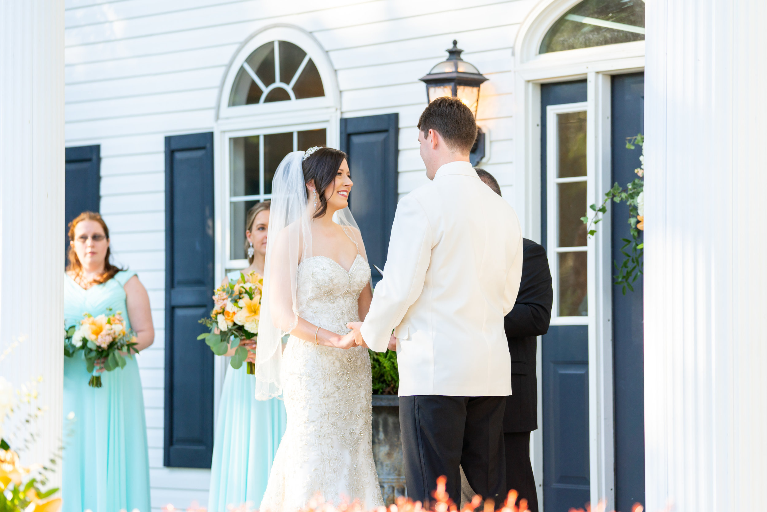 Bride and groom in front of blue door at Harvest House wedding