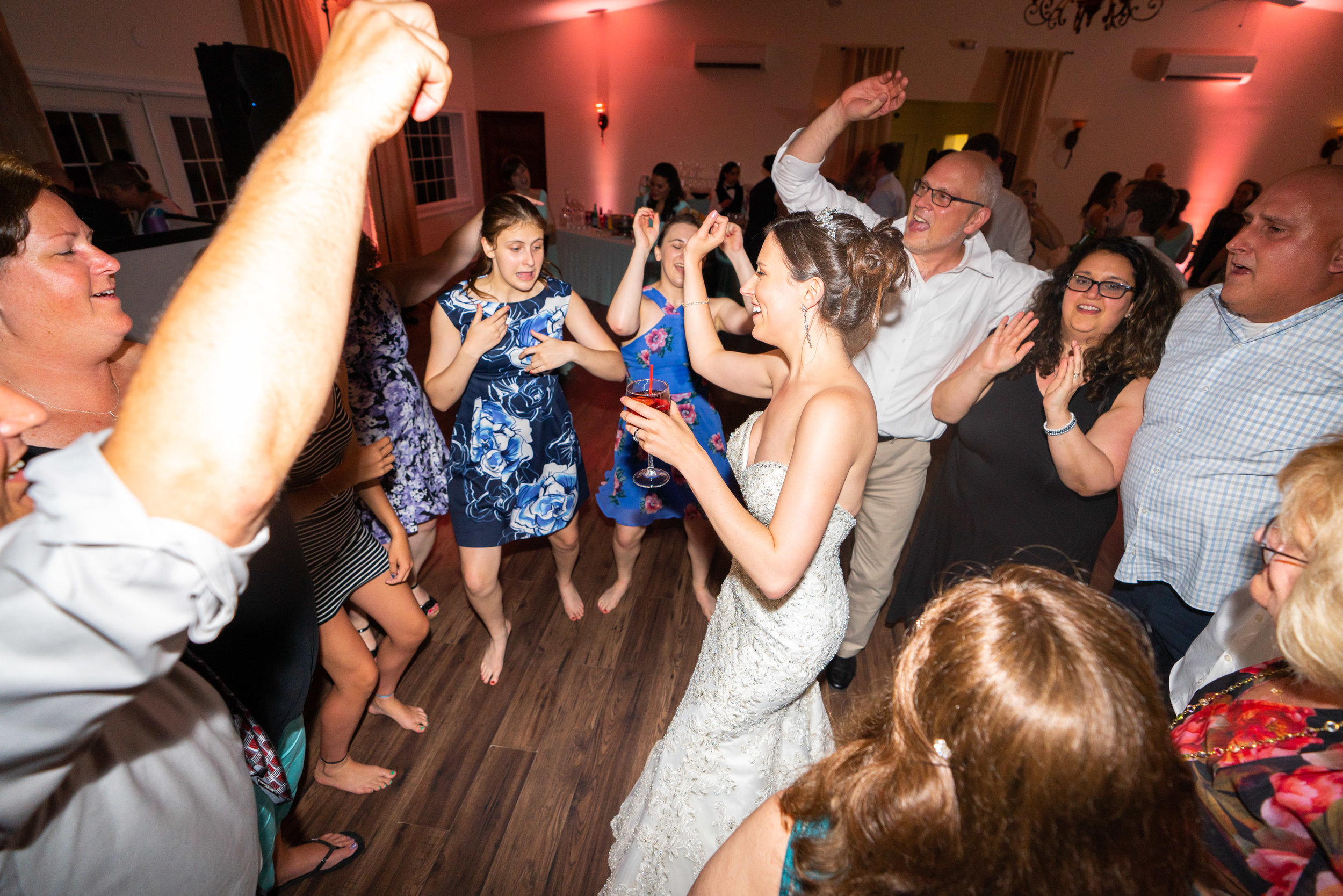 Bride dancing in the center of a group of guests at Harvest House