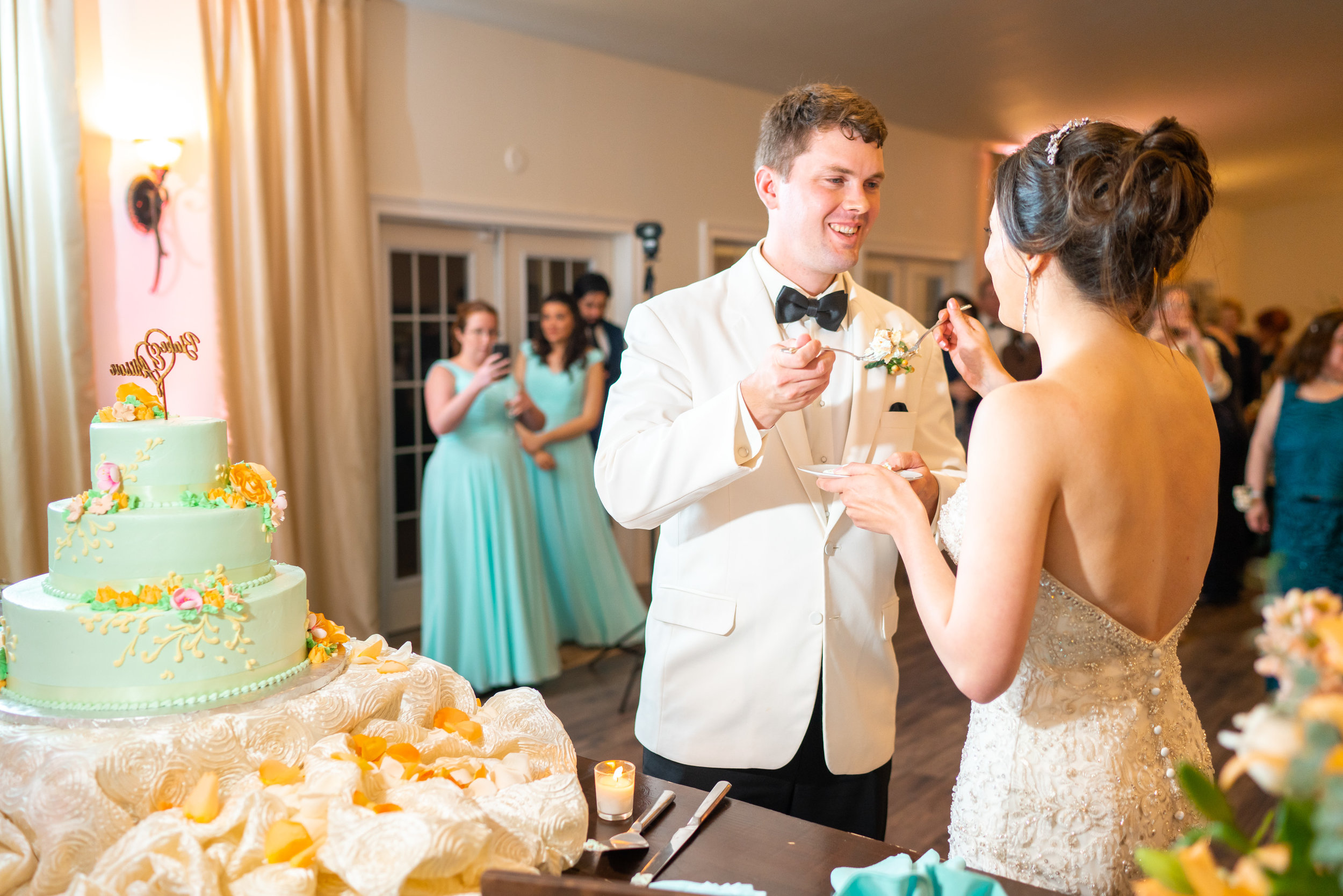 Bride and groom feeding each other wedding cake with forks