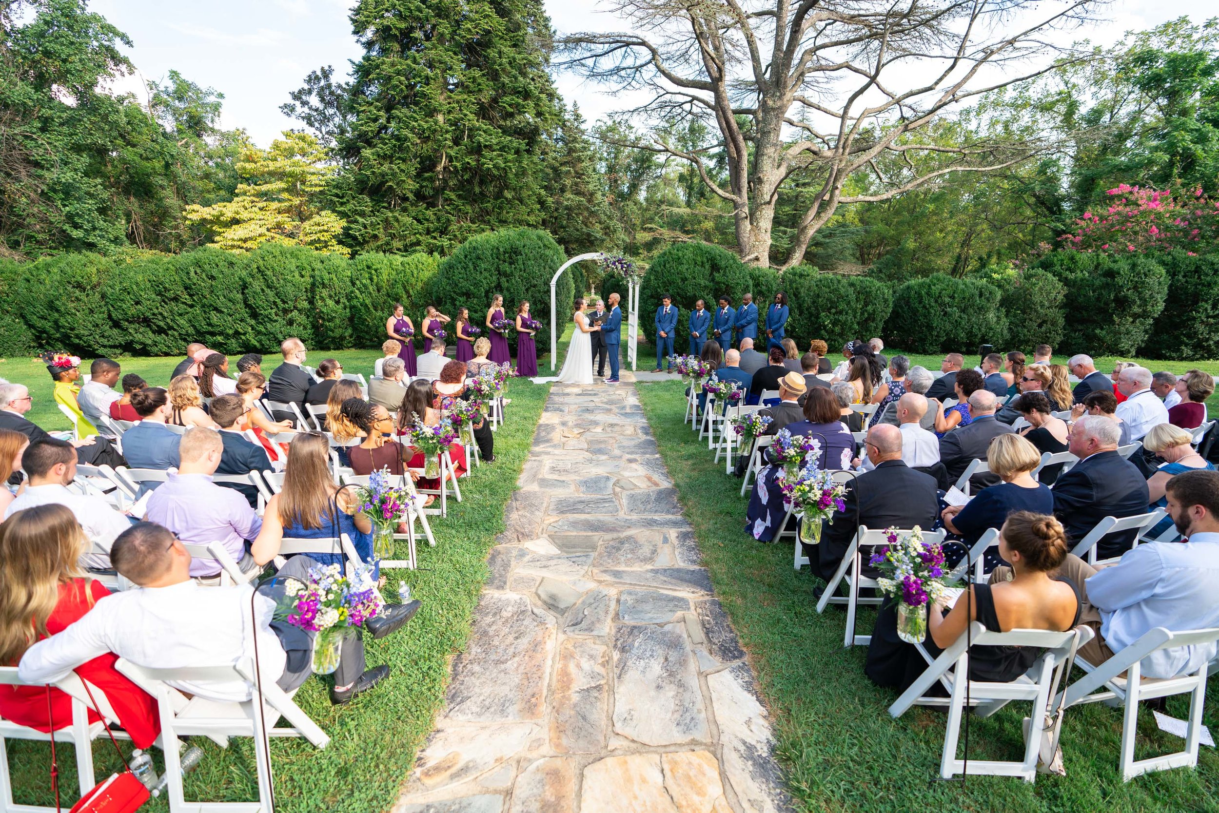 Wide shot of wedding ceremony and guests at outdoor wedding at Rust Manor House with Jeff Maszal