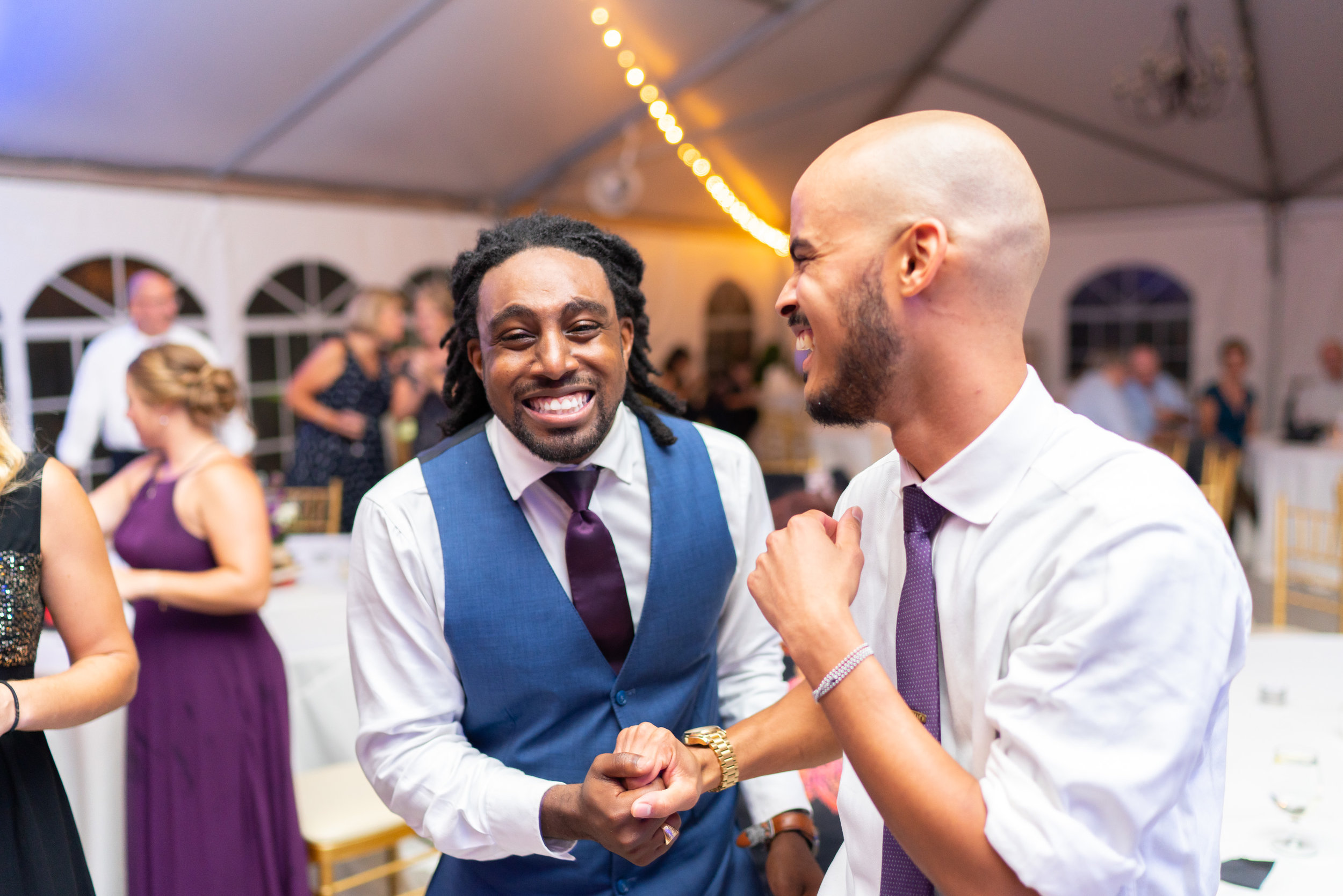Groom and his best man celebrating and dancing with blue uprights