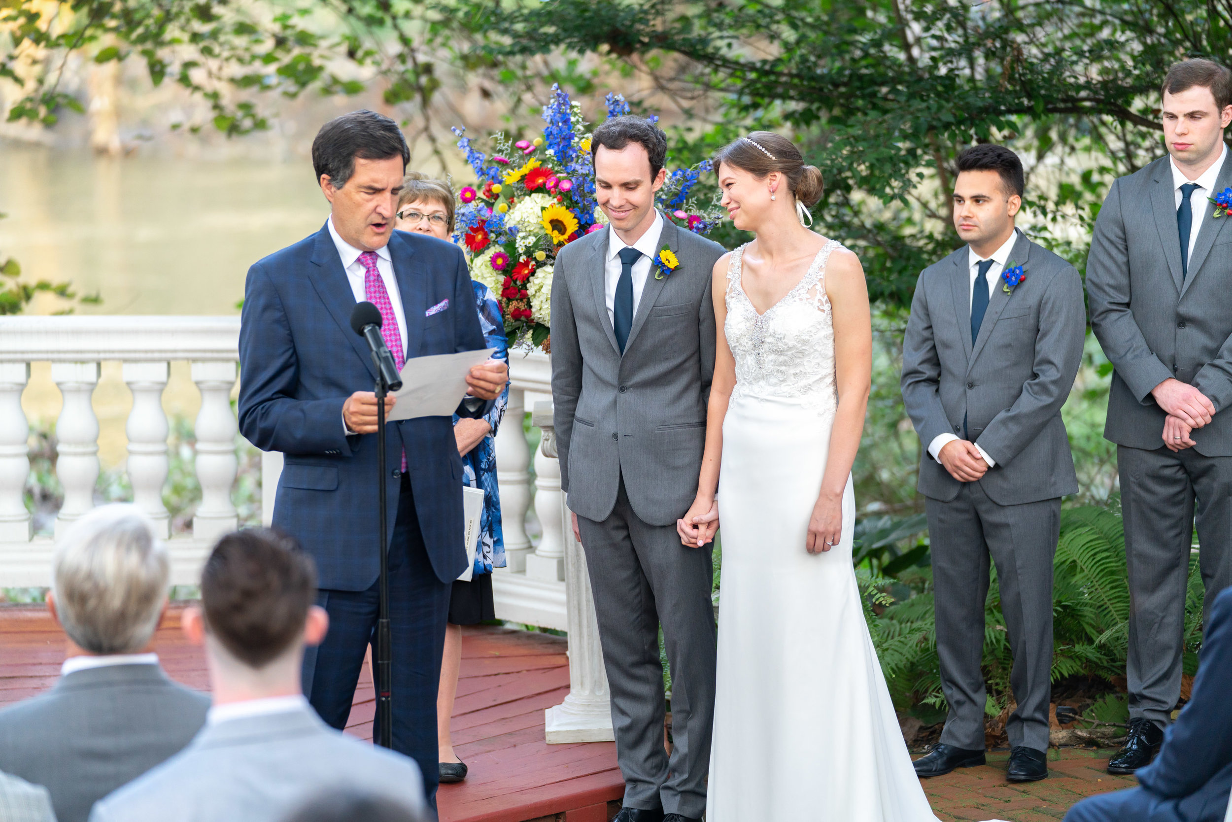 Bride and groom listening to reading during ceremony Morilee Myka gown