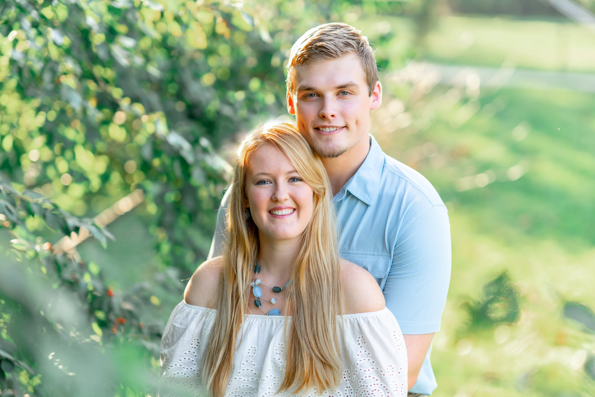 Groom with his arms around bride's waist at Baker Park in Frederick Maryland