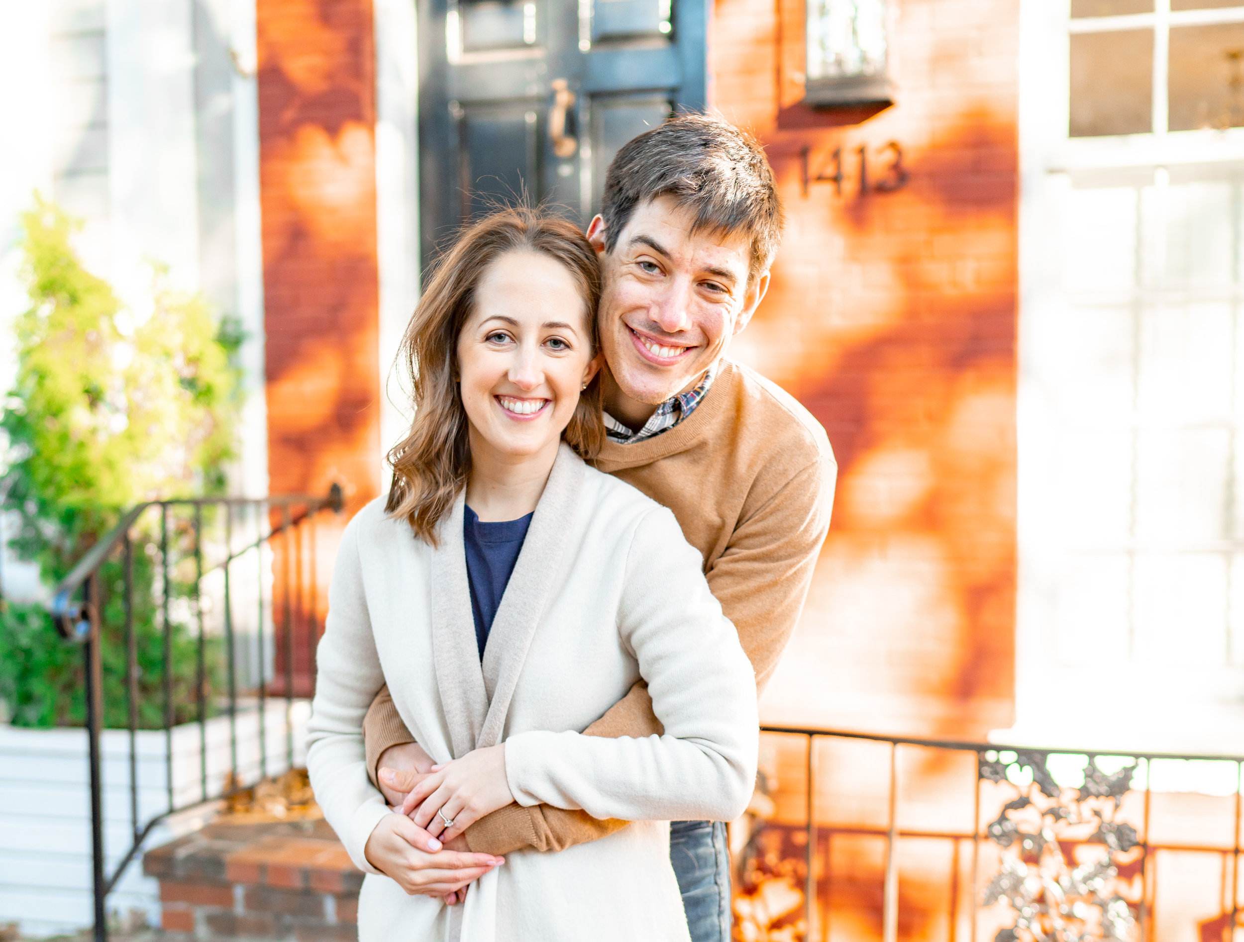 Bride and groom during engagement shoot in front of colorful Georgetown townhouses