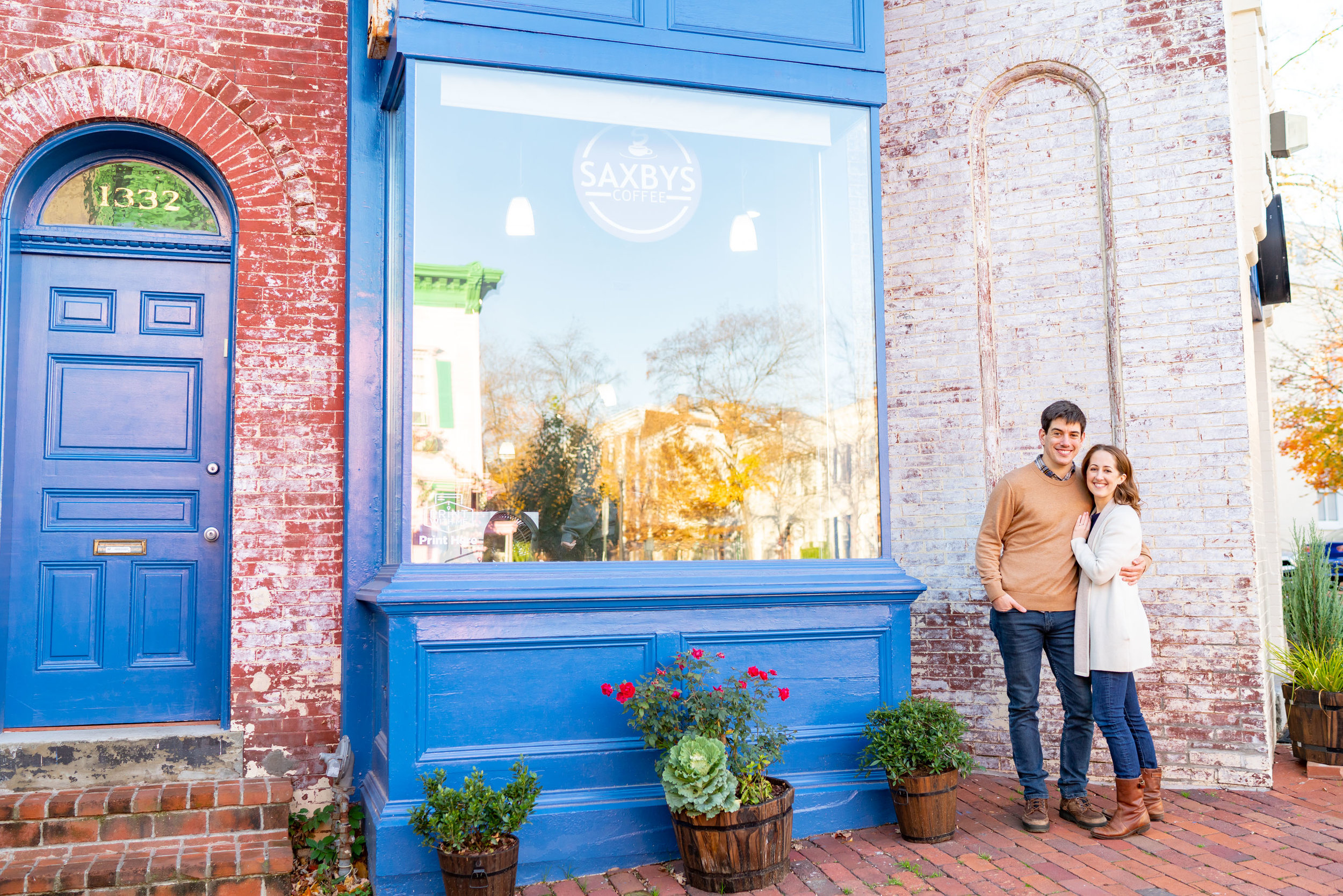 Bride and groom standing in front of blue front Saxby's coffee shop for engagement photo