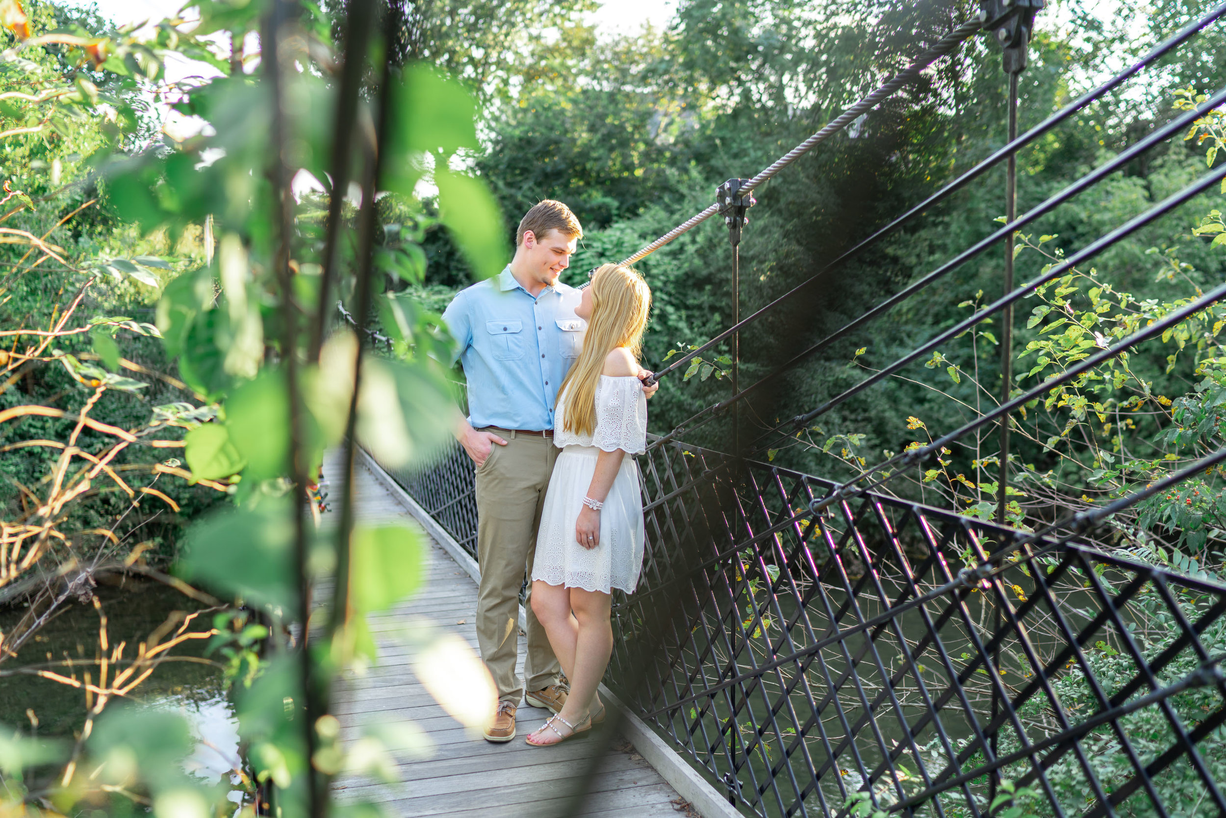 Baker Park suspension bridge engagement photo with bride and groom in summer