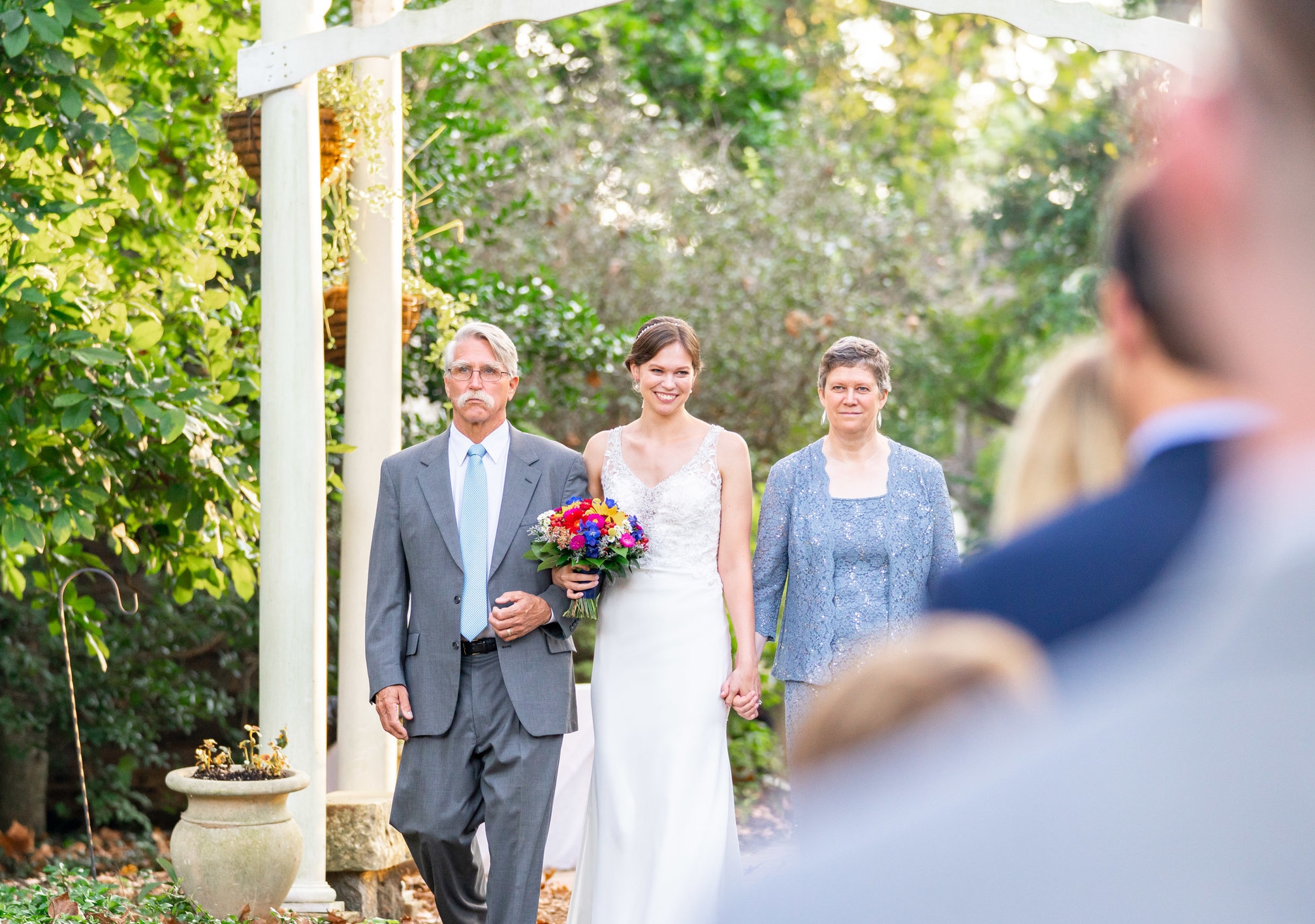 Parents walking the bride down the aisle at outdoor ceremony at Elkridge Furnace Inn