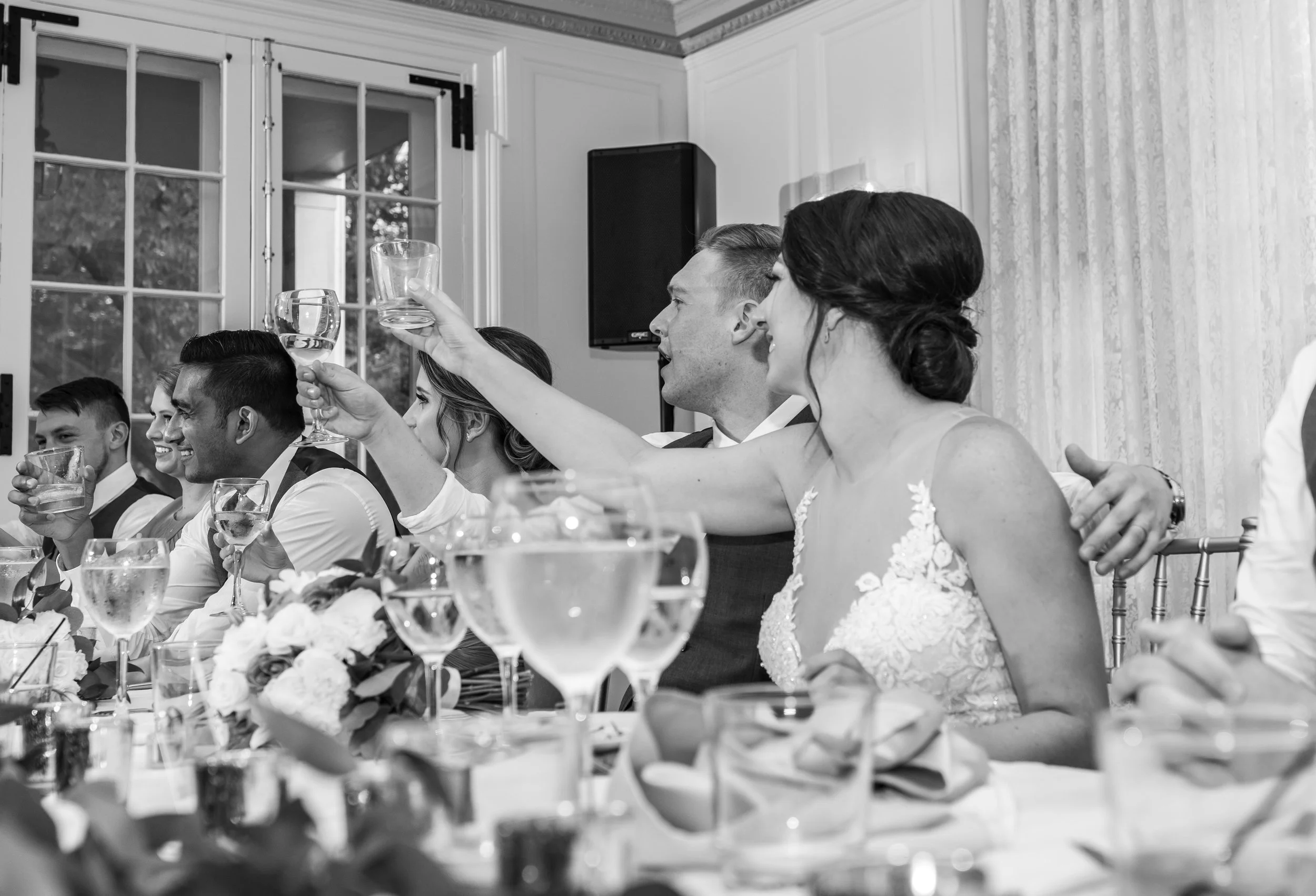 Bride and groom cheers their glasses to the bride's father at Glenview Mansion