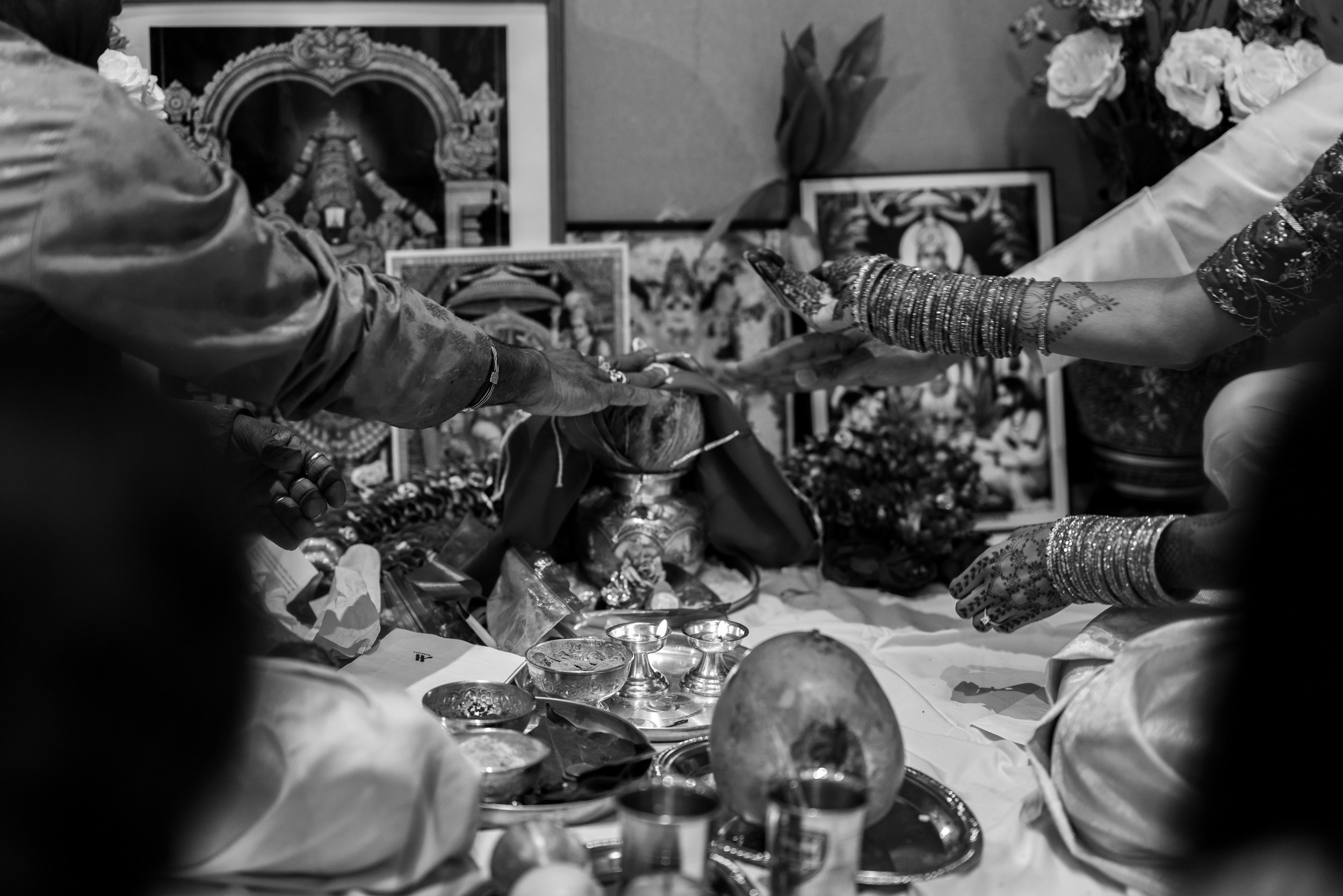 Black and white photo of hands during the indian puja wedding ceremony