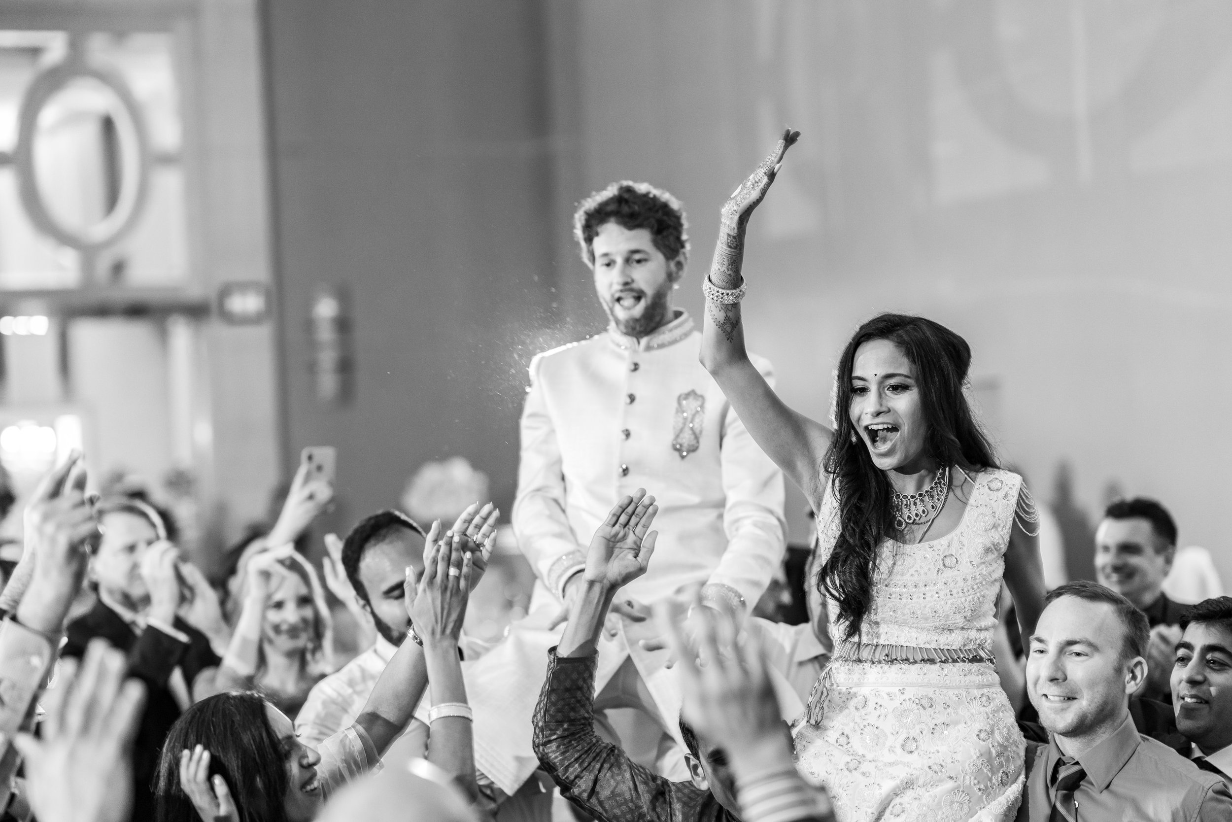 Bride and groom lifted in the crowd at indian wedding reception in maryland