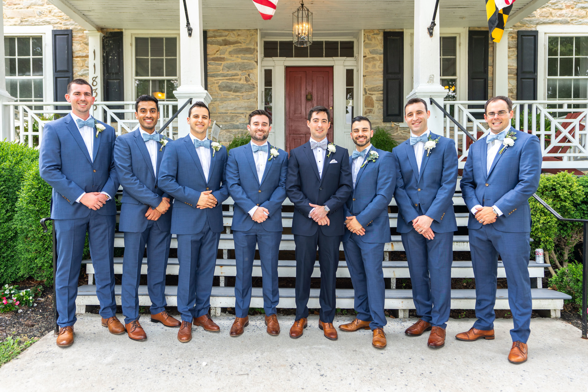 Groomsmen wearing blue J Crew suits and Tie Bar bow ties in front of Springfield Manor Winery and Distillery