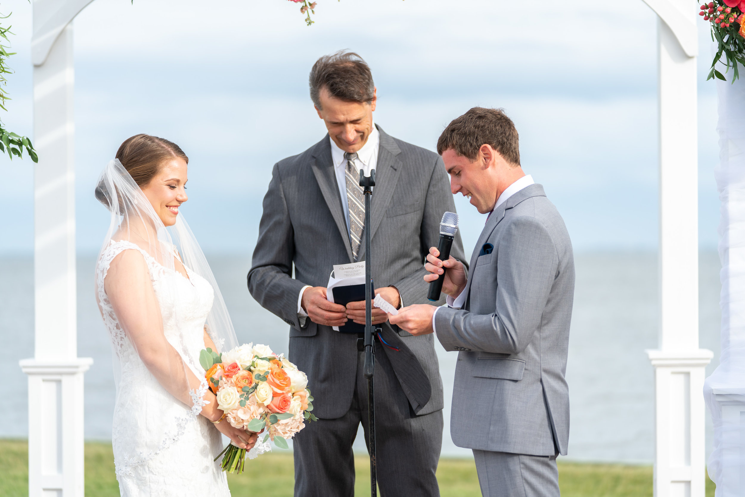 Bride and groom under awning at Rehoboth Beach Country Club on the water