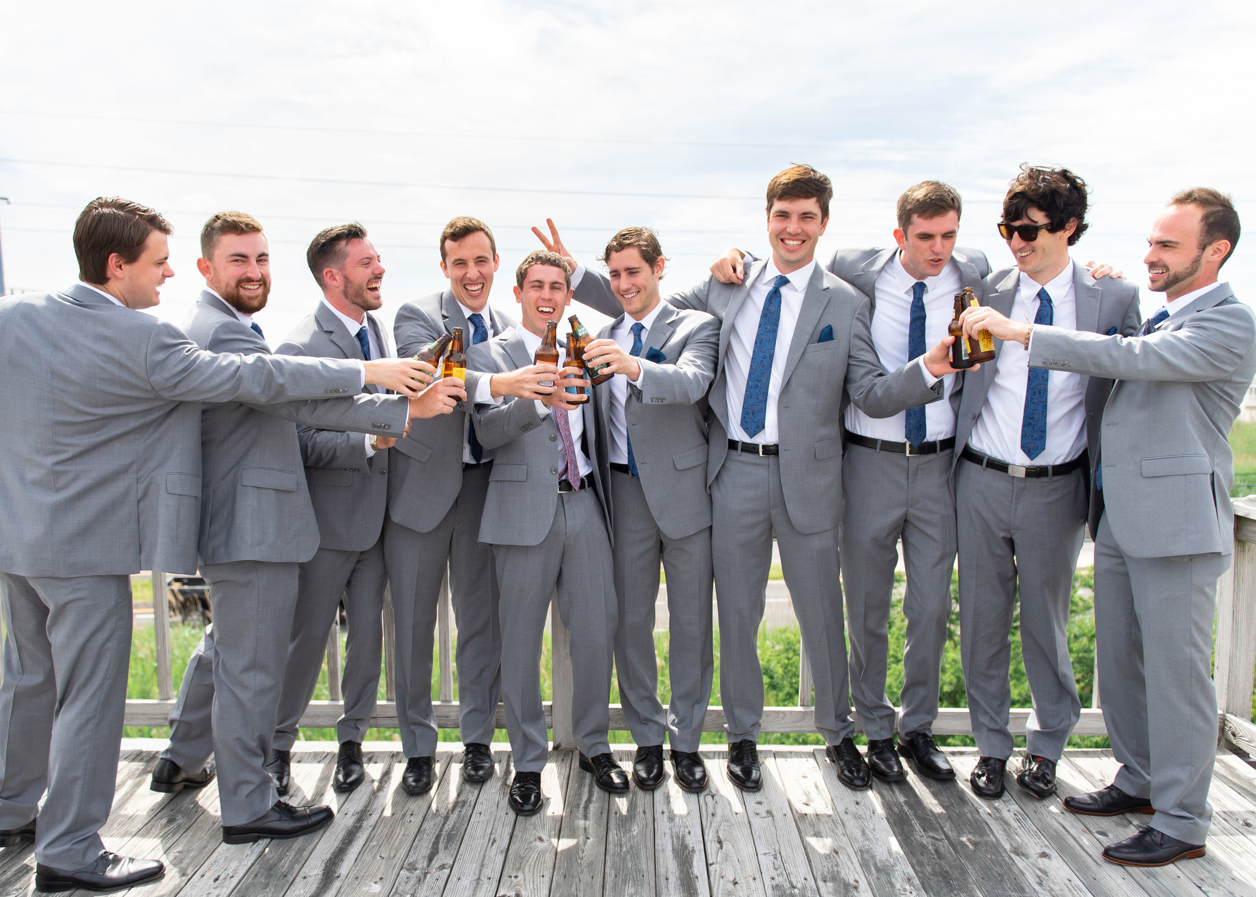 Groom and groomsmen toasting on the deck before wedding ceremony