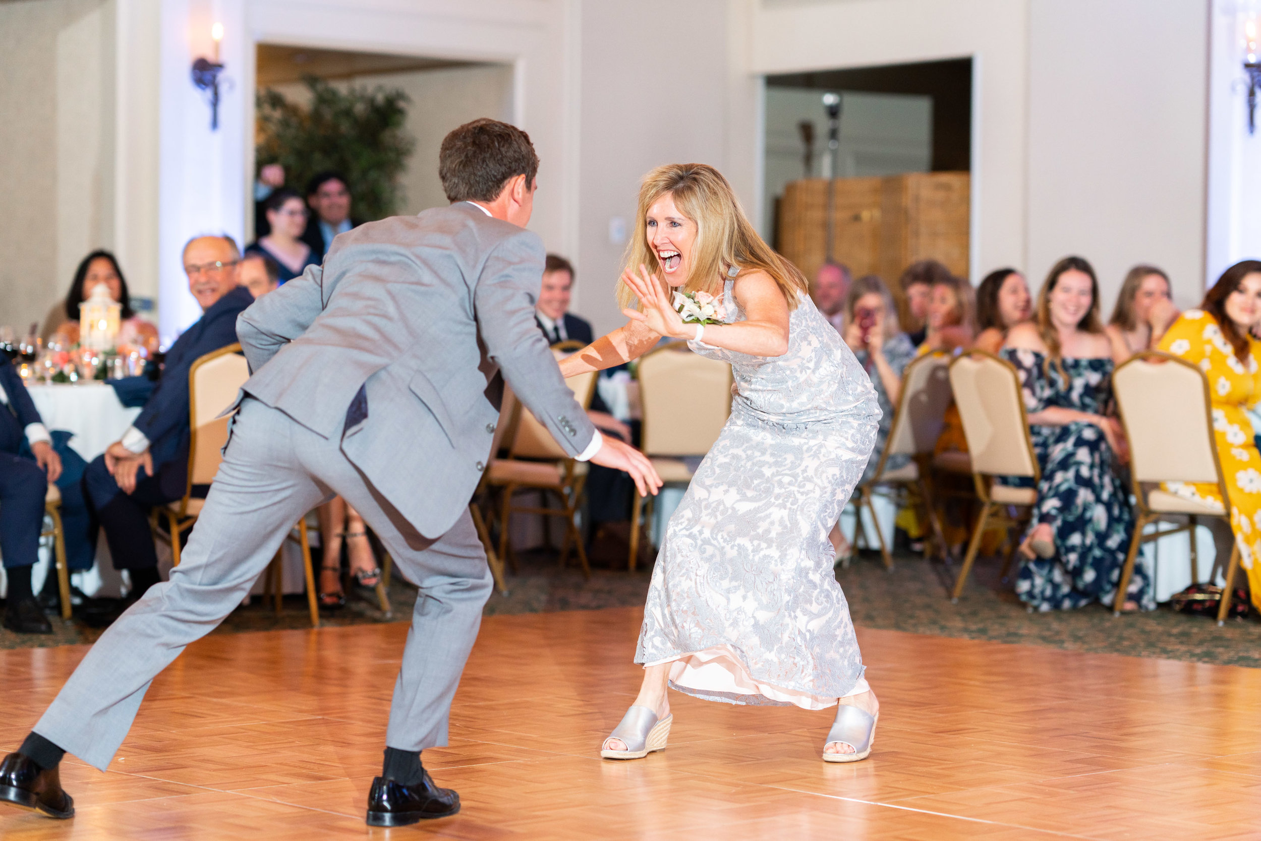 Mother and son dance at rehoboth beach country club reception hall with purple uplighting
