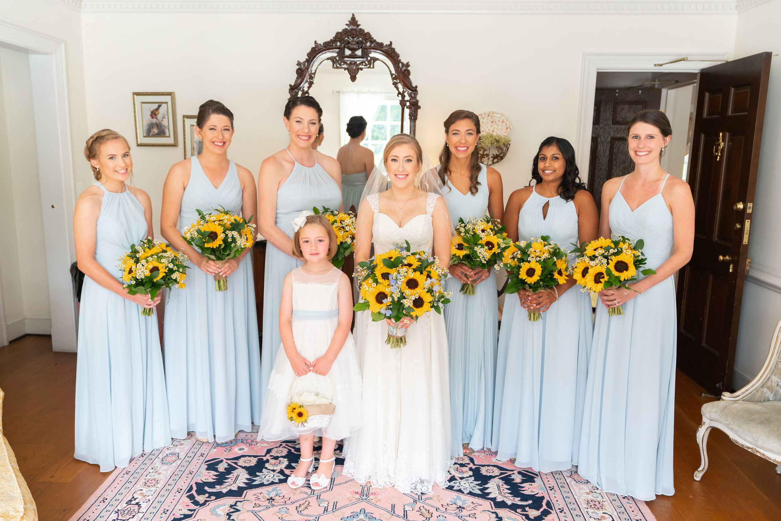 Sunflower bouquets and light blue Azazie dresses at Stone Manor Country Club