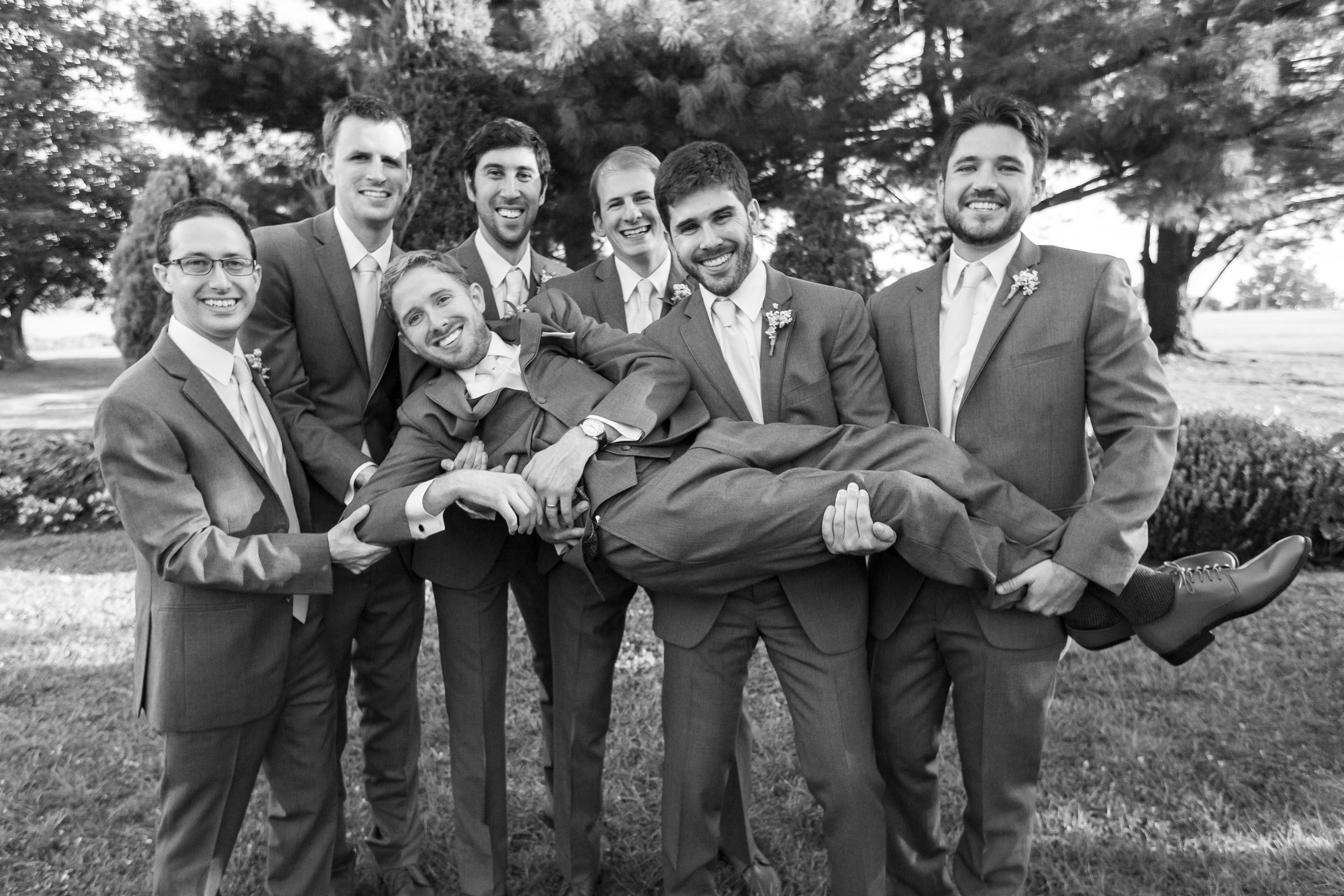 Groomsmen holding groom up at Stone Manor Country Club