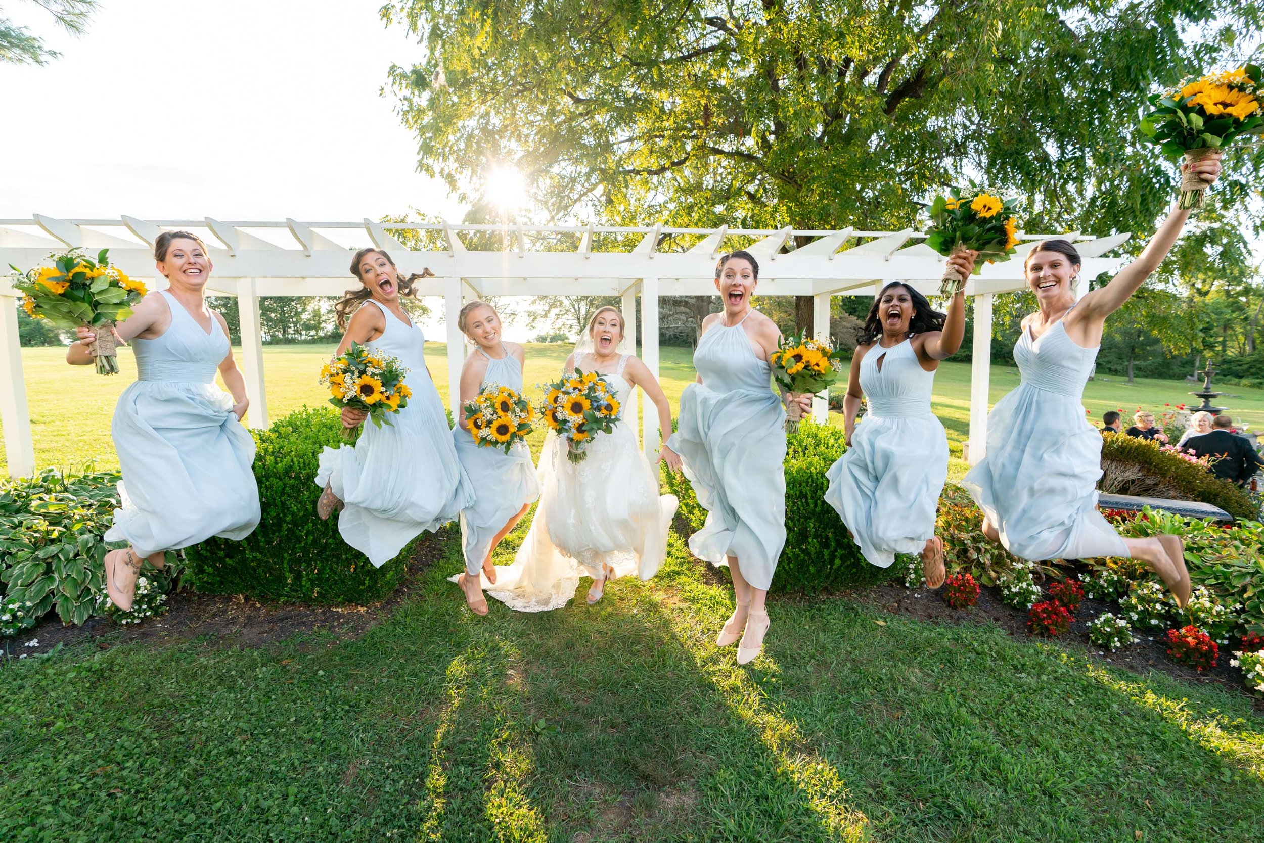 Bride and bridesmaids jumping in the air photo with blue azazie gowns