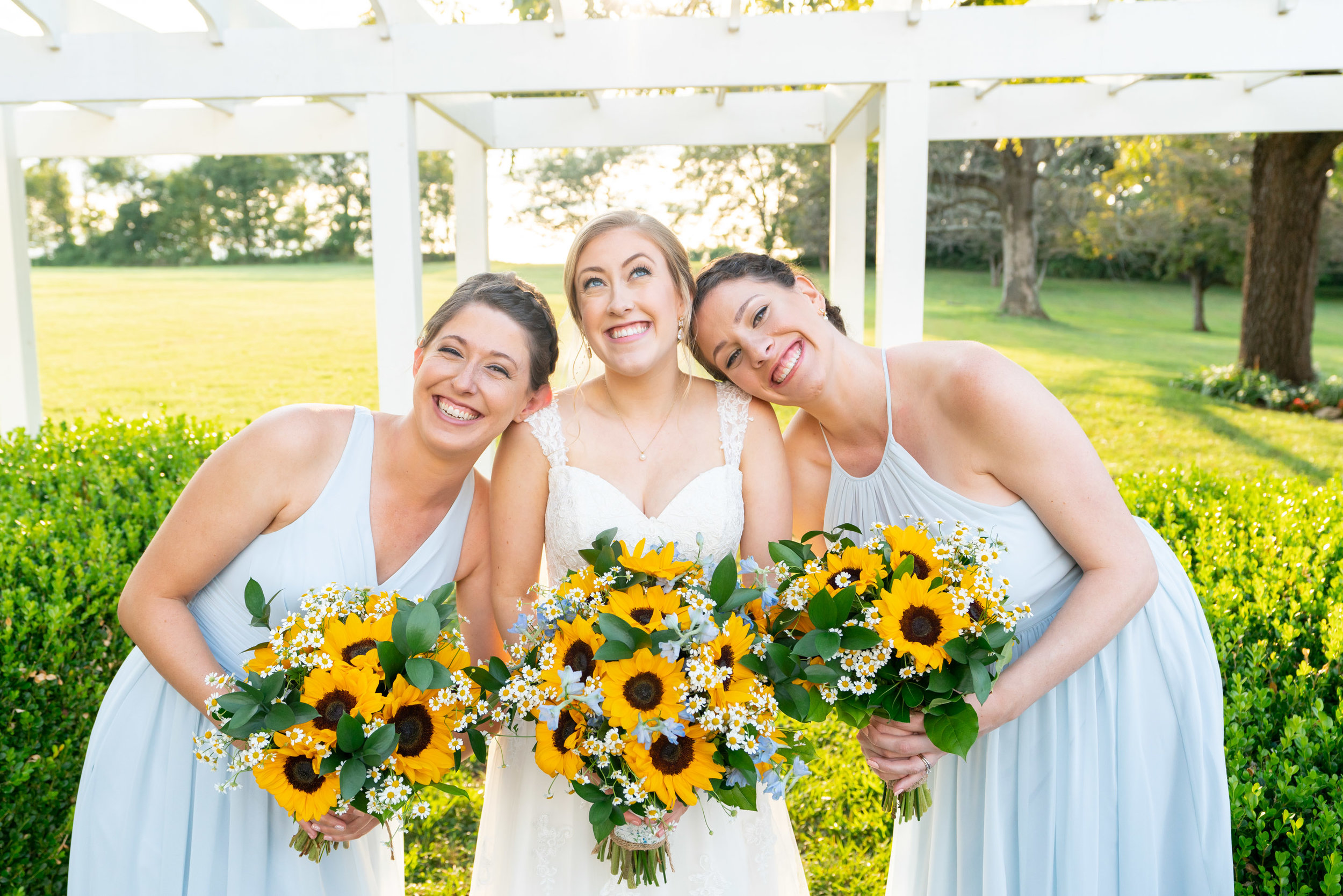 Bride and bridesmaids in blue azazie and sunflower bouquets at Frederick wedding venue