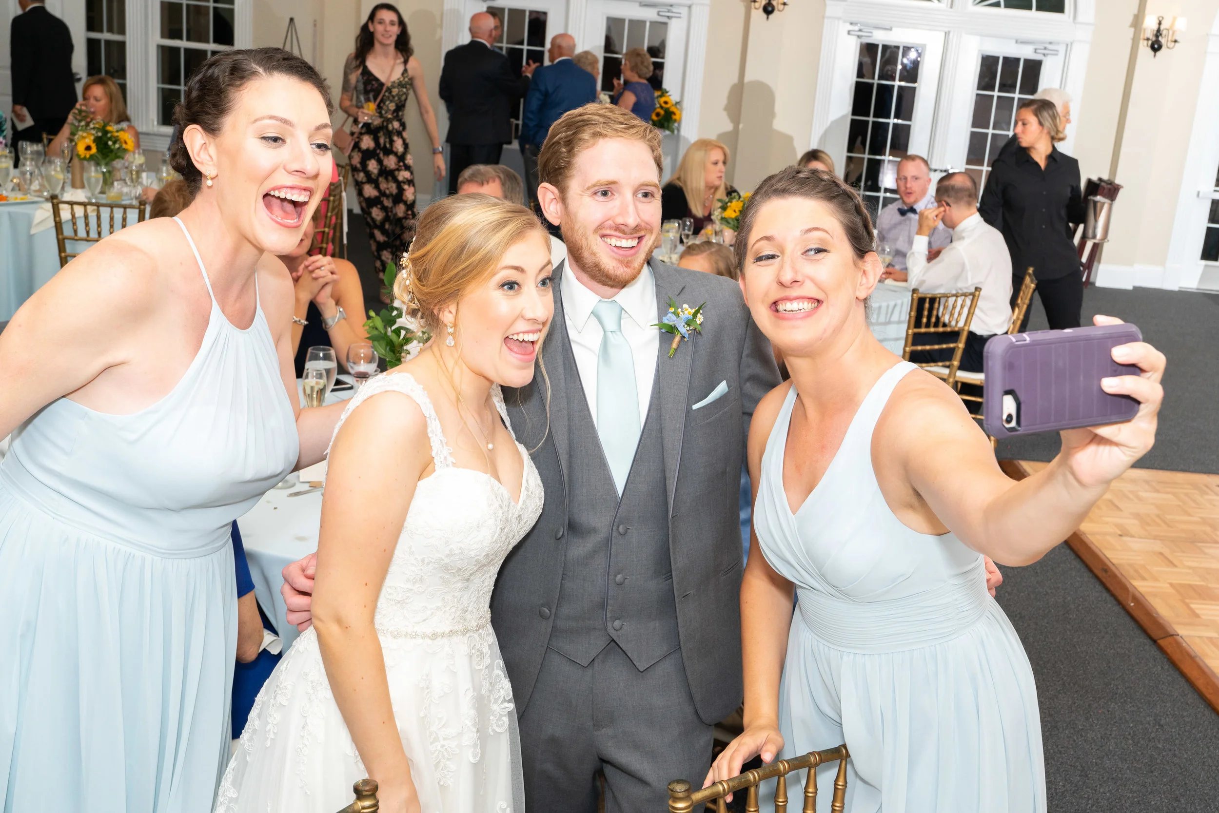 bride and groom taking a selfie with bridesmaids