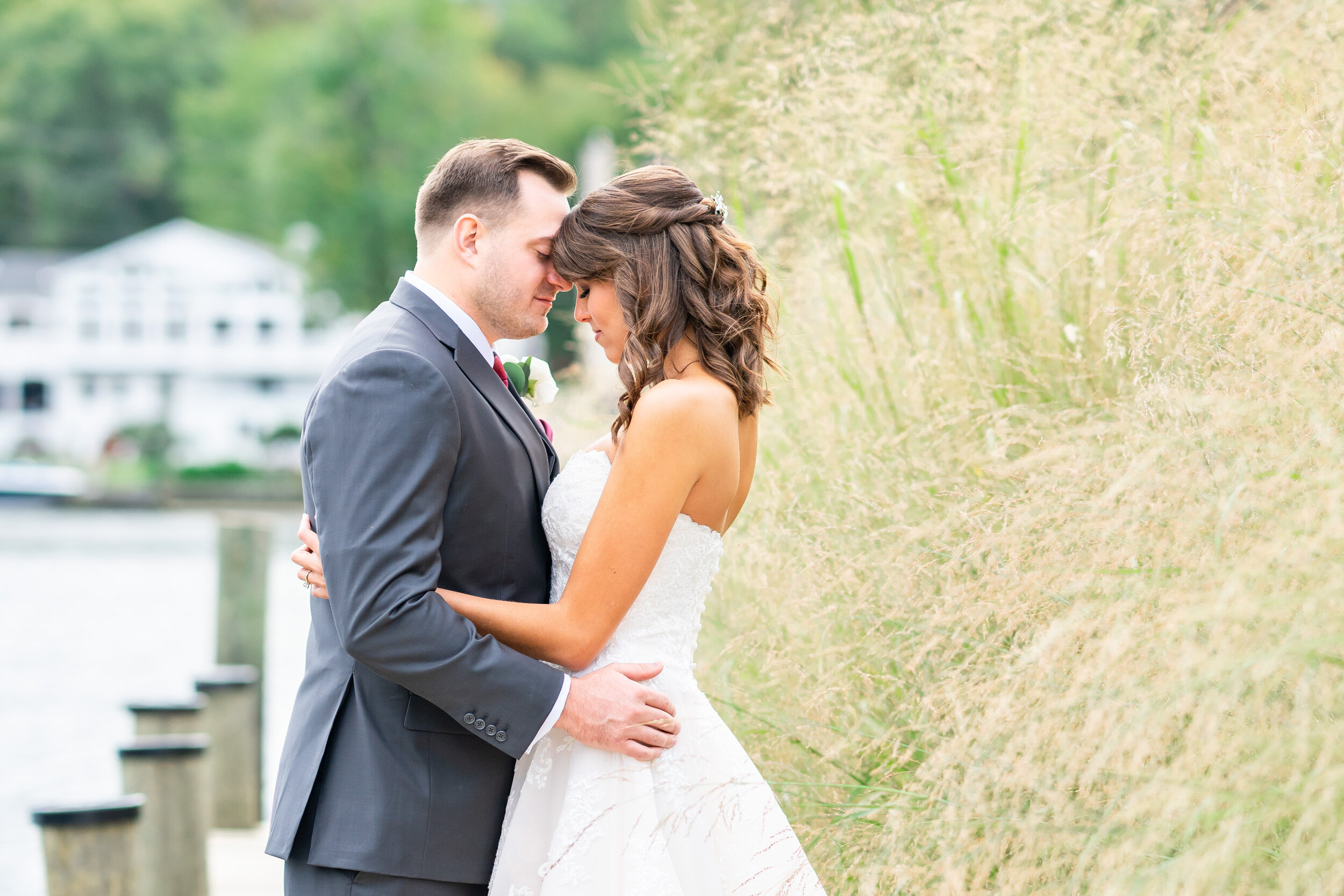 Bride and groom touching foreheads on the dock at Occoquan regional park