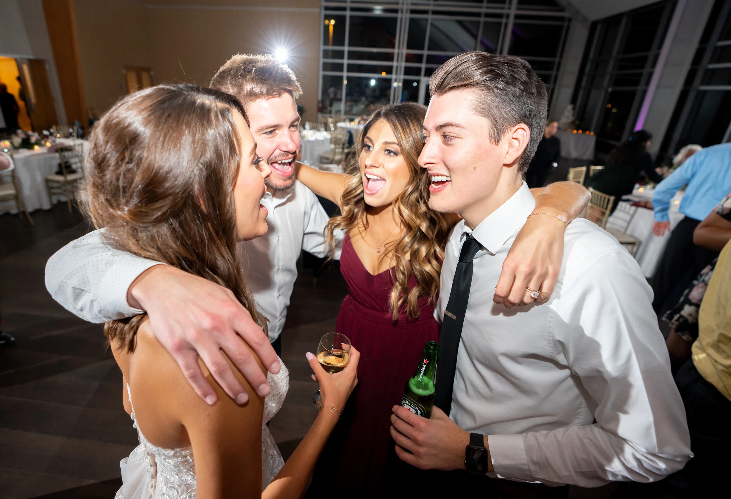Bride and guests hugging on the dance floor with DJ Luccio