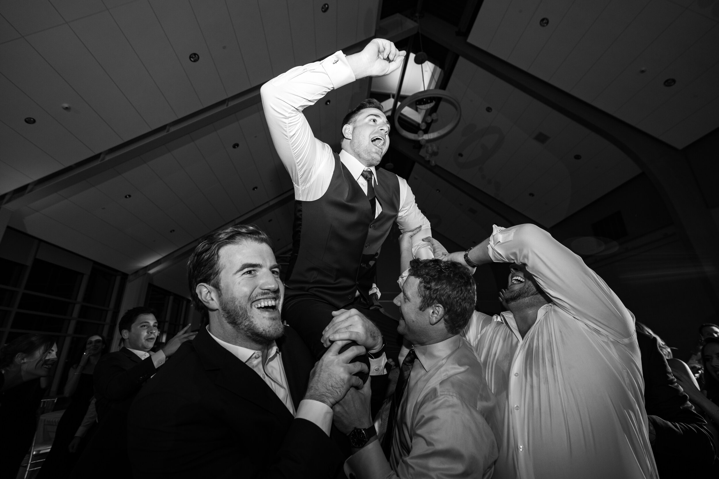 Groom lifted in the air at fun crazy wedding reception