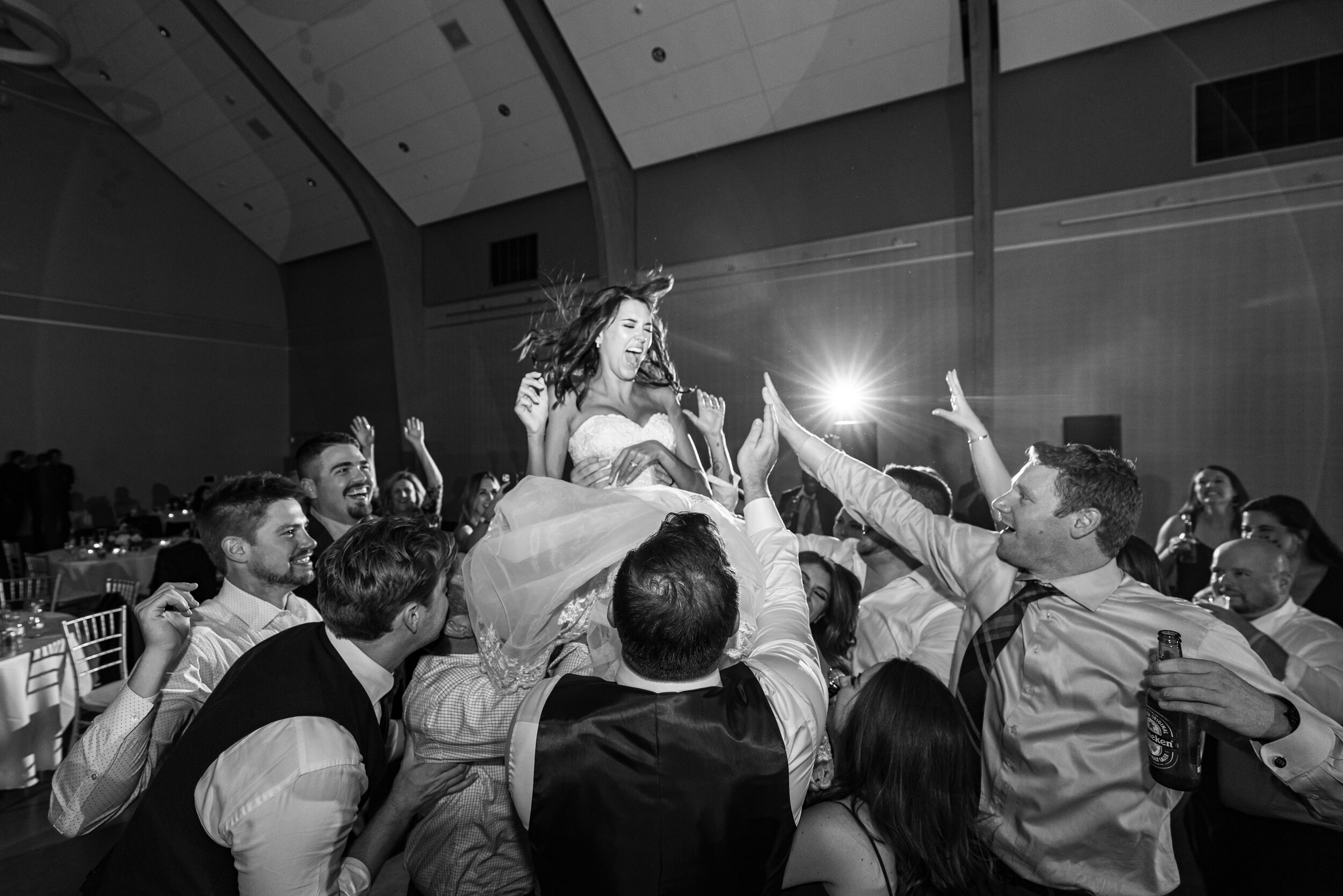 Bride being lifted into the air during crazy wedding reception