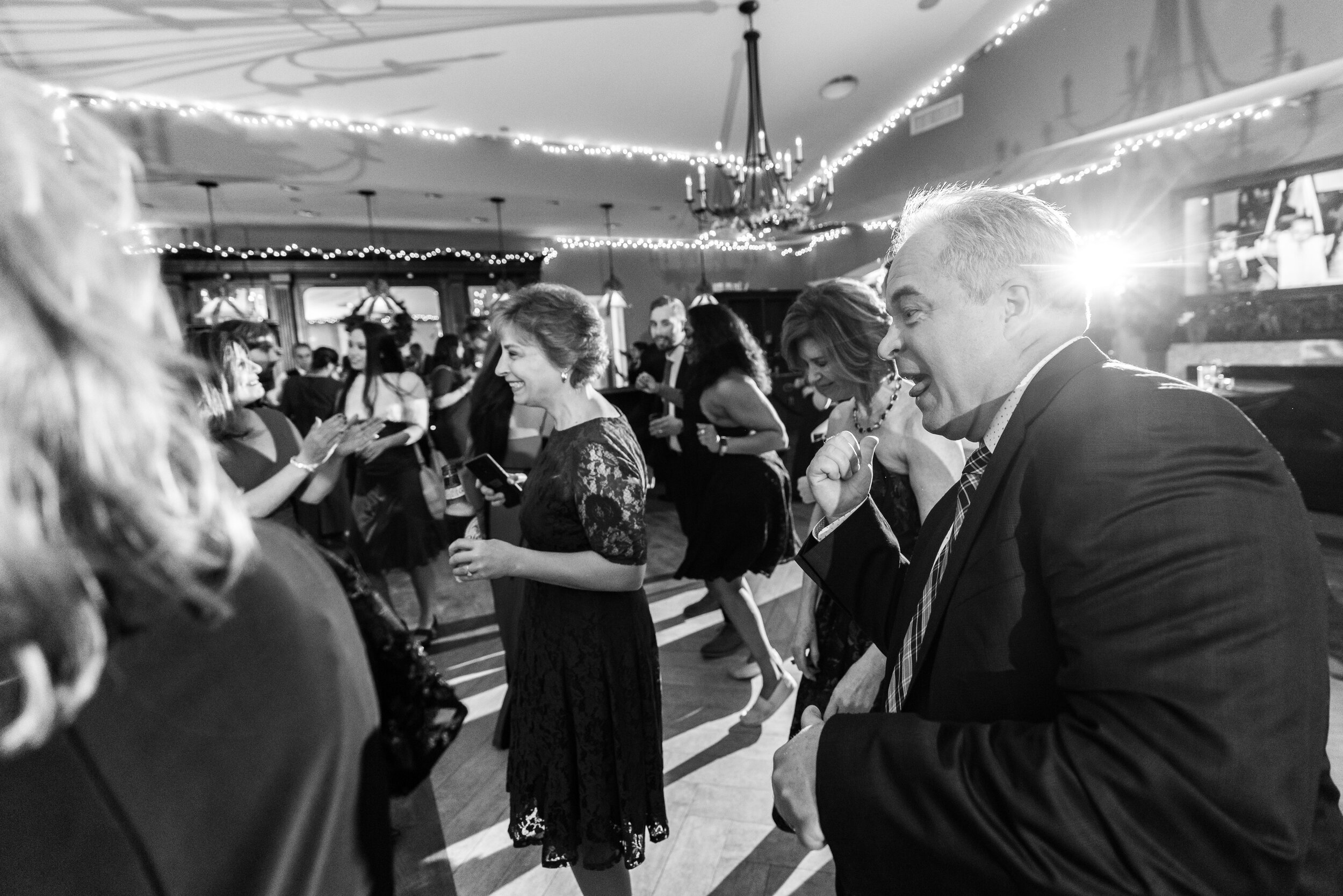 Wedding guests dance during wedding reception at Ospreys at Belmont Bay