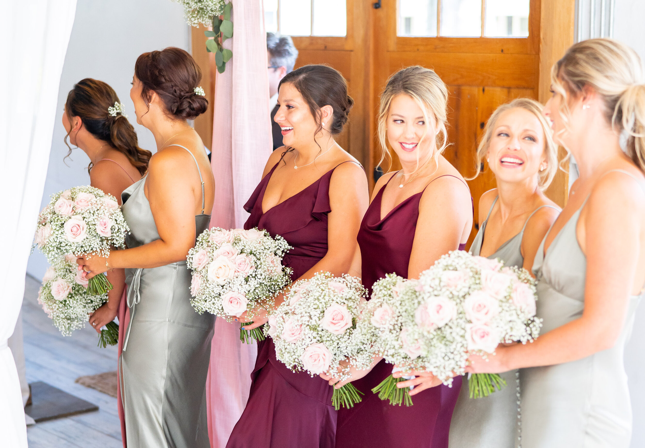 Bridesmaids in sage, burgundy and ballet dresses with baby's breath and blush roses