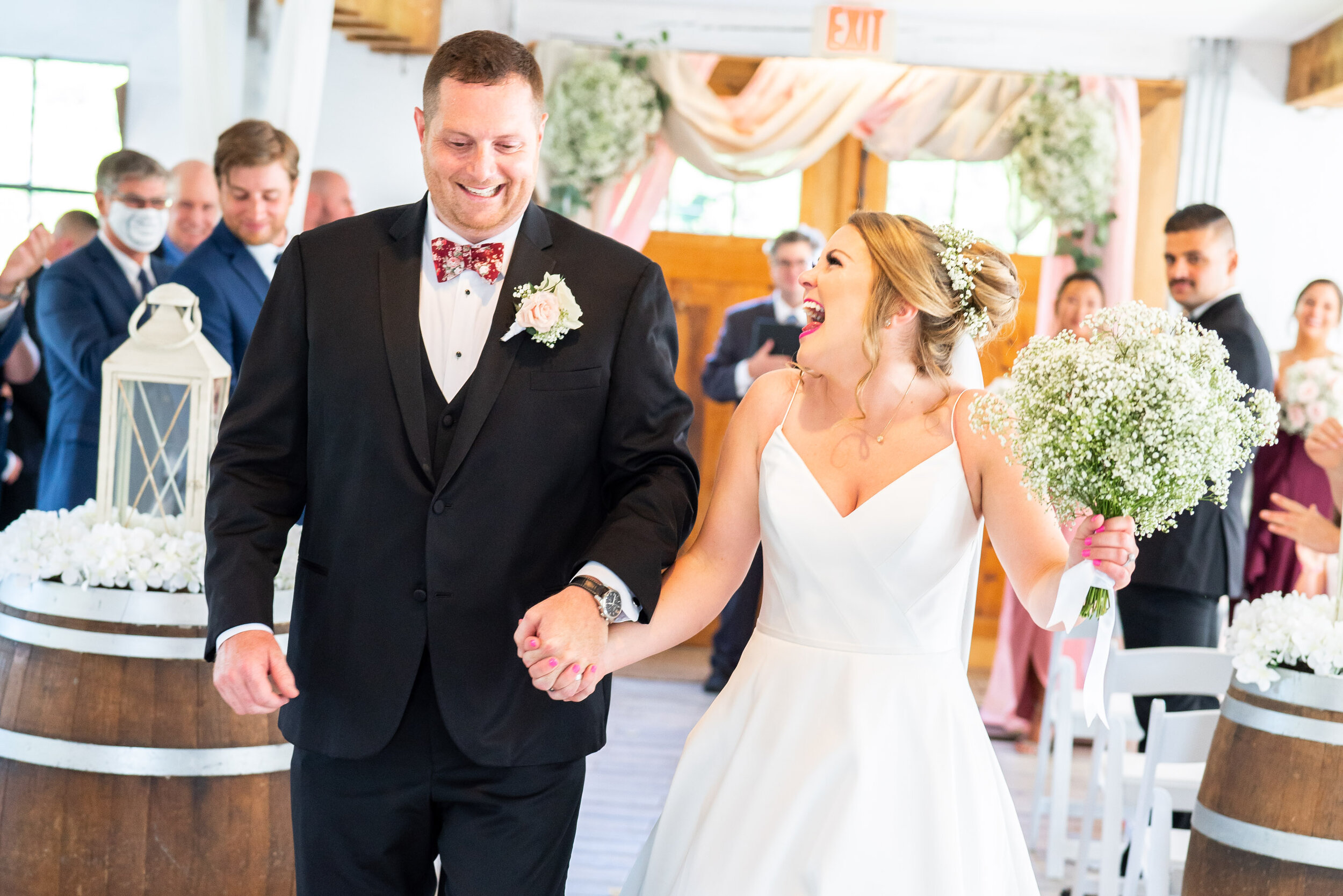 Bride and groom walking back down the aisle with baby's breath bouquet
