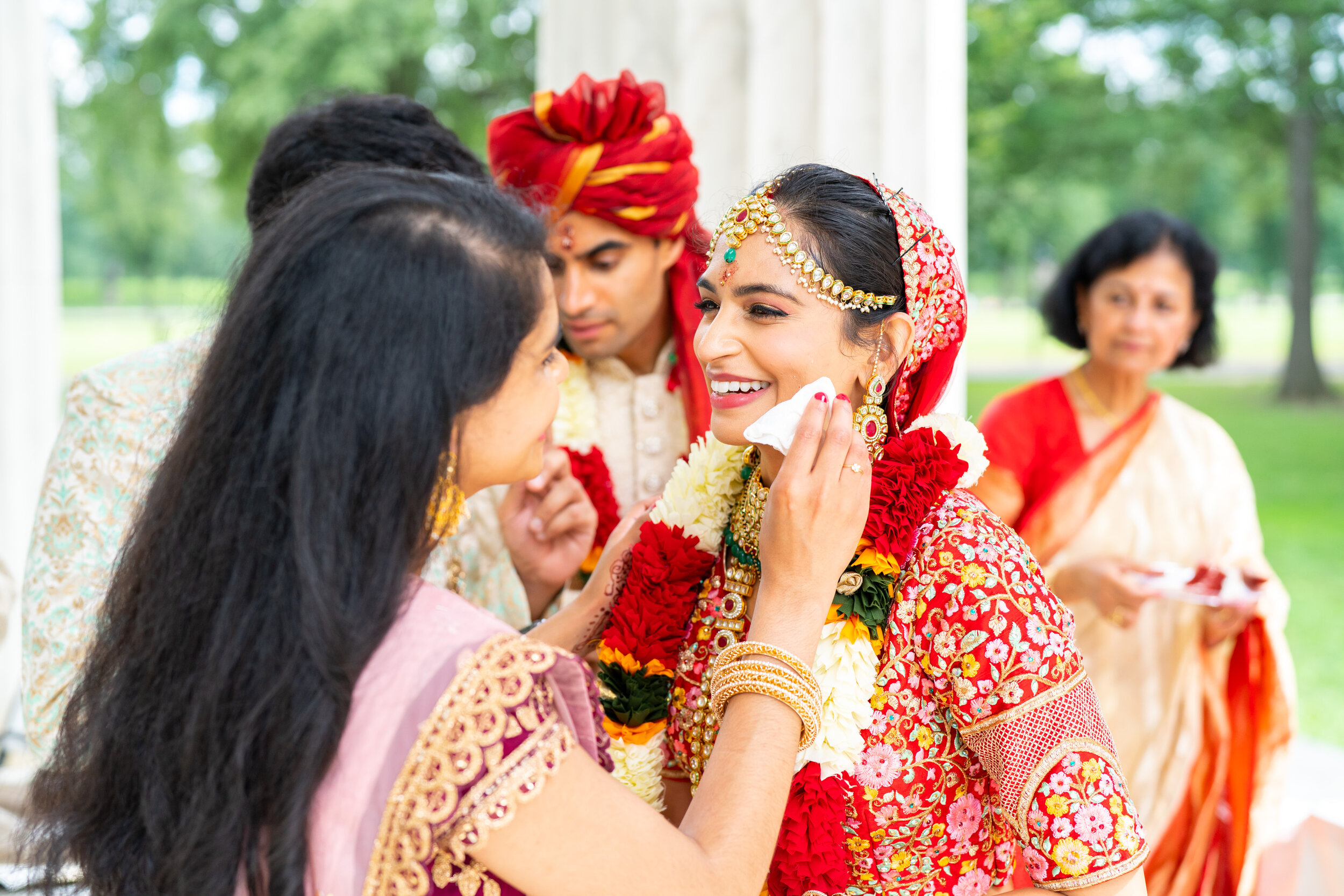 Bride's sister wiping cake off face of bride in Sabyasachi in DC