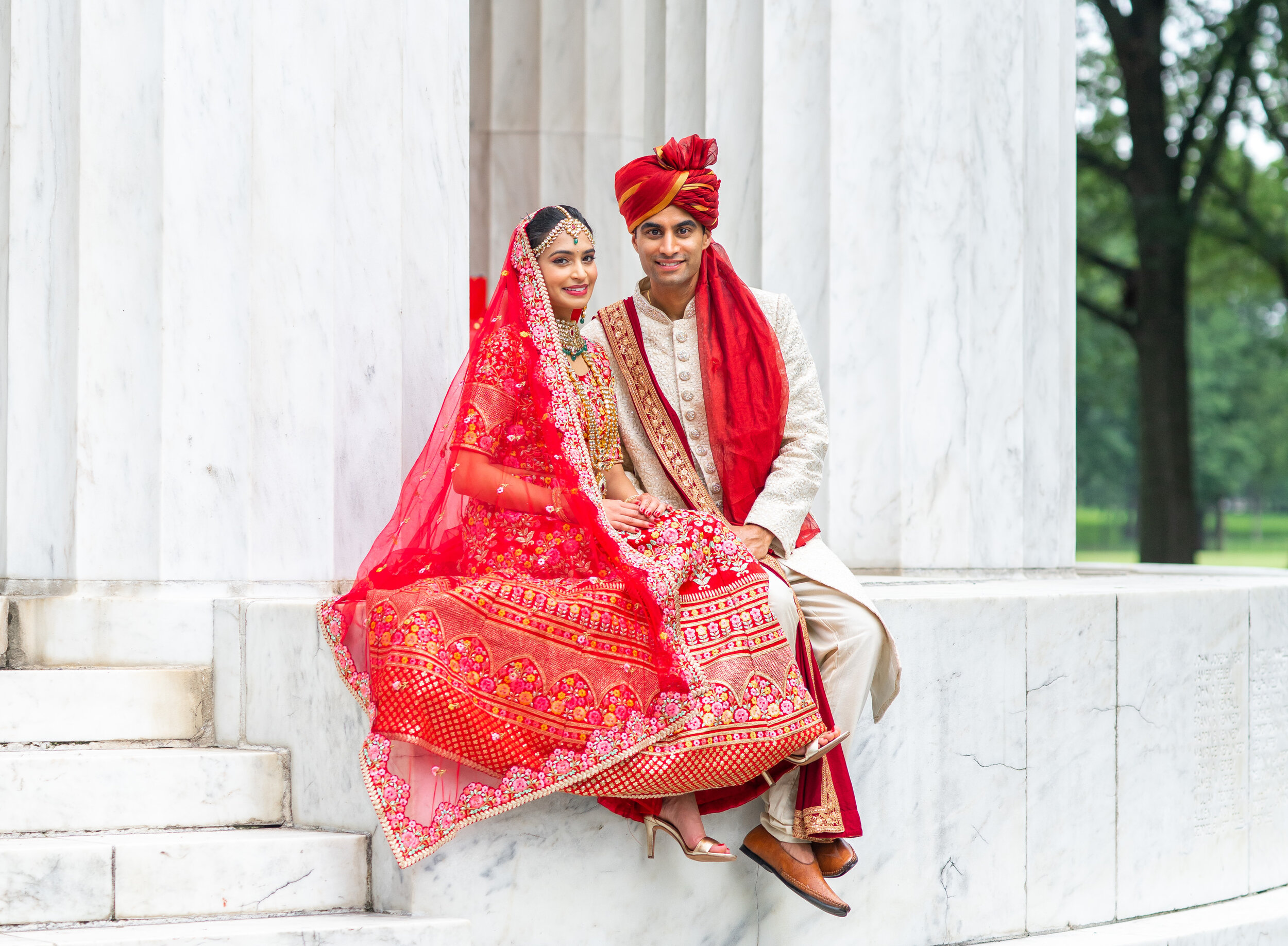 Indian bride and groom sitting on steps of DC War Memorial 