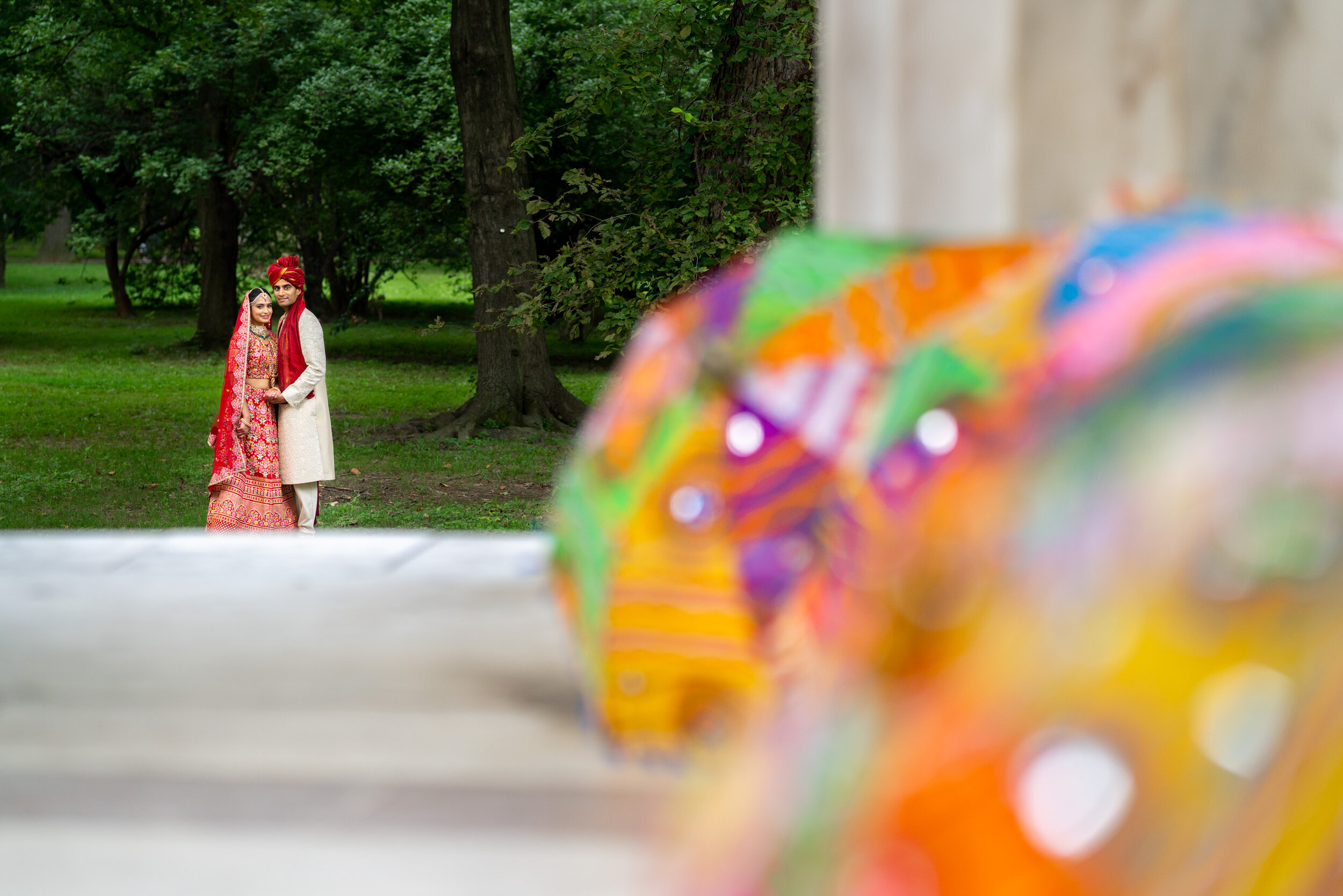Dramatic portrait of indian bride and groom with colorful parasols on DC War Memorial