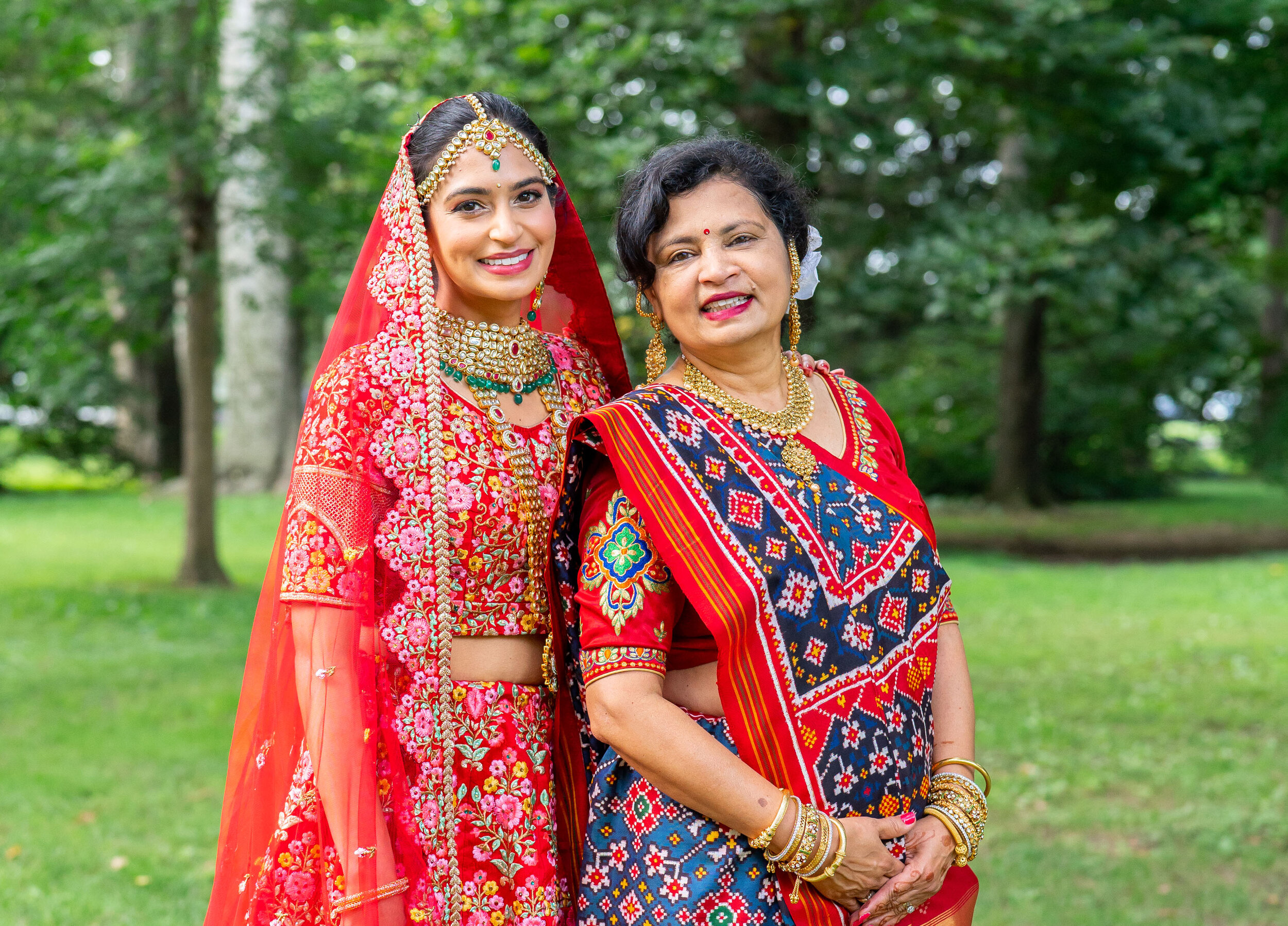 Indian bride with mom in red and pink Sabyasachi lehenga