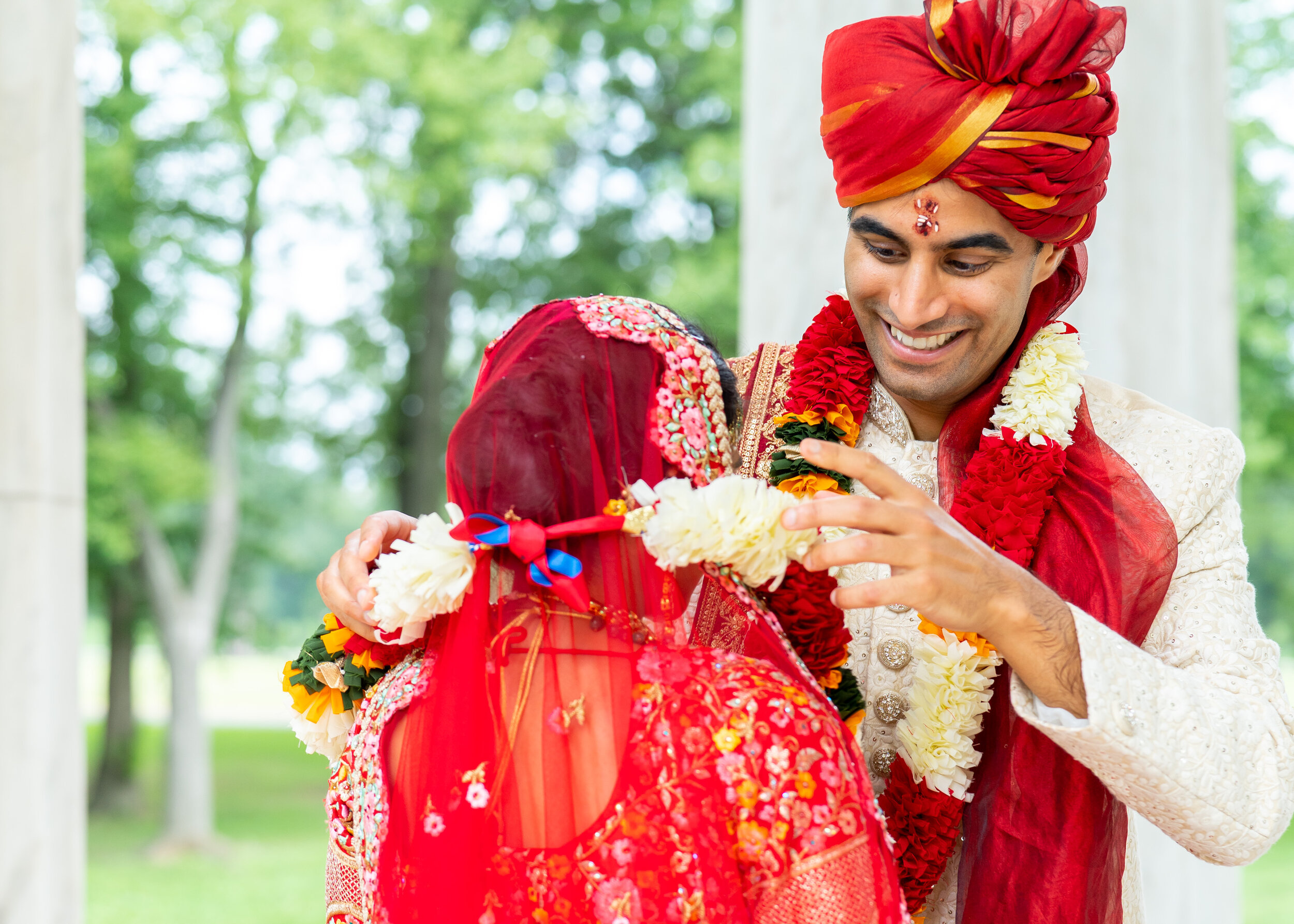 Indian groom putting floral garland on bride varmala jaimala