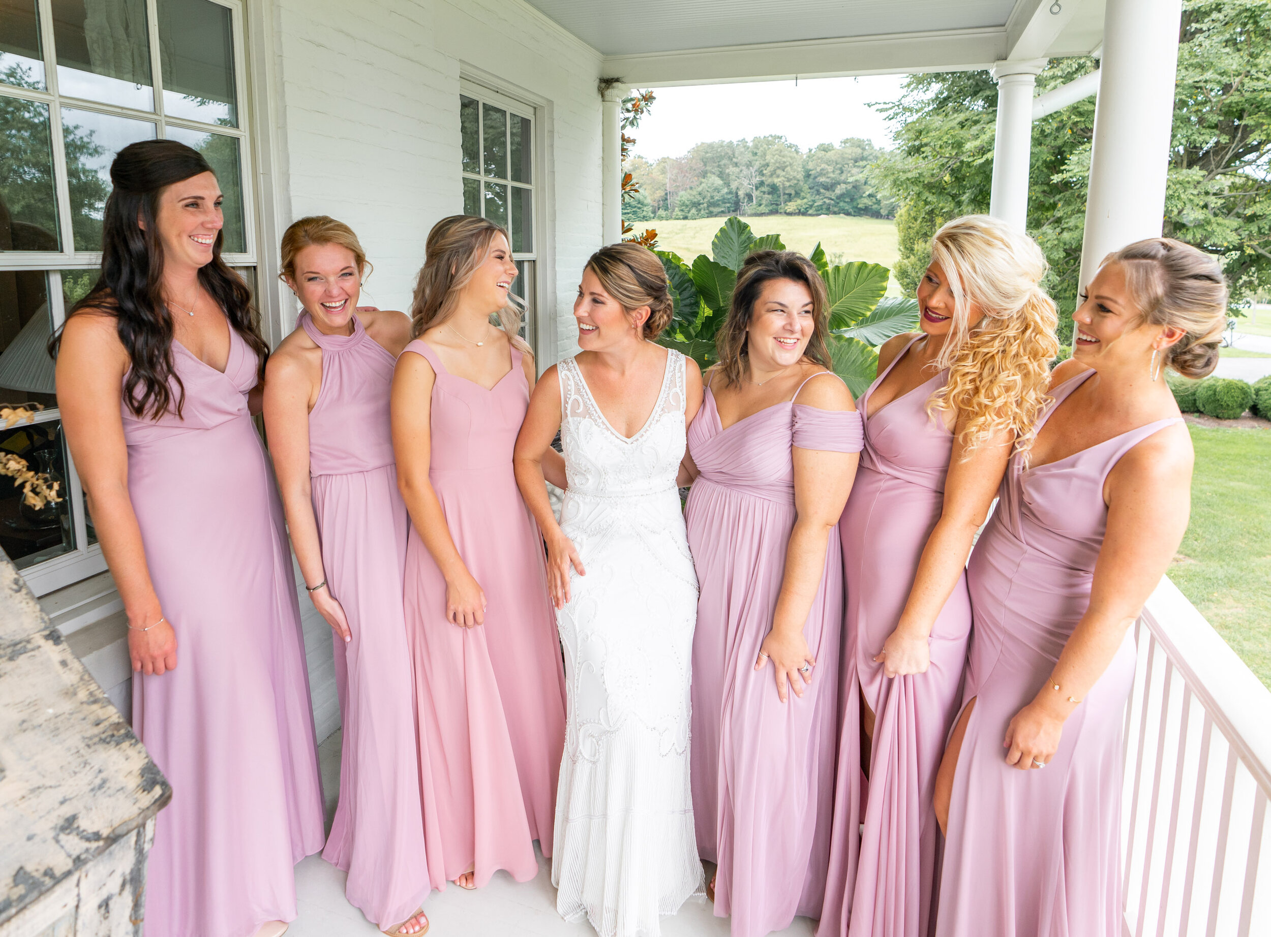 Bride and bridesmaids on the upper front porch at Glen Ellen Farm in Maryland