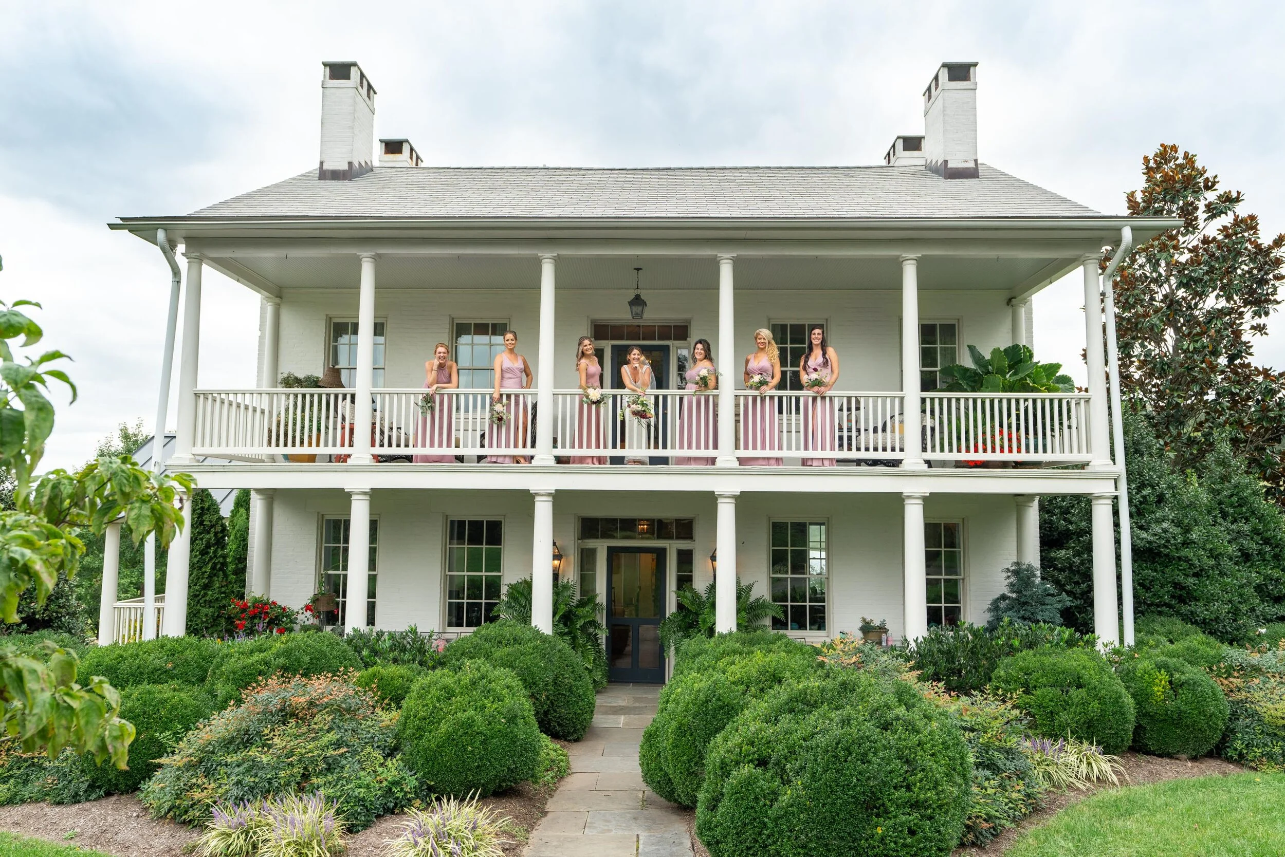 Bride and bridesmaids on the top front porch upstairs at Glen Ellen Farm