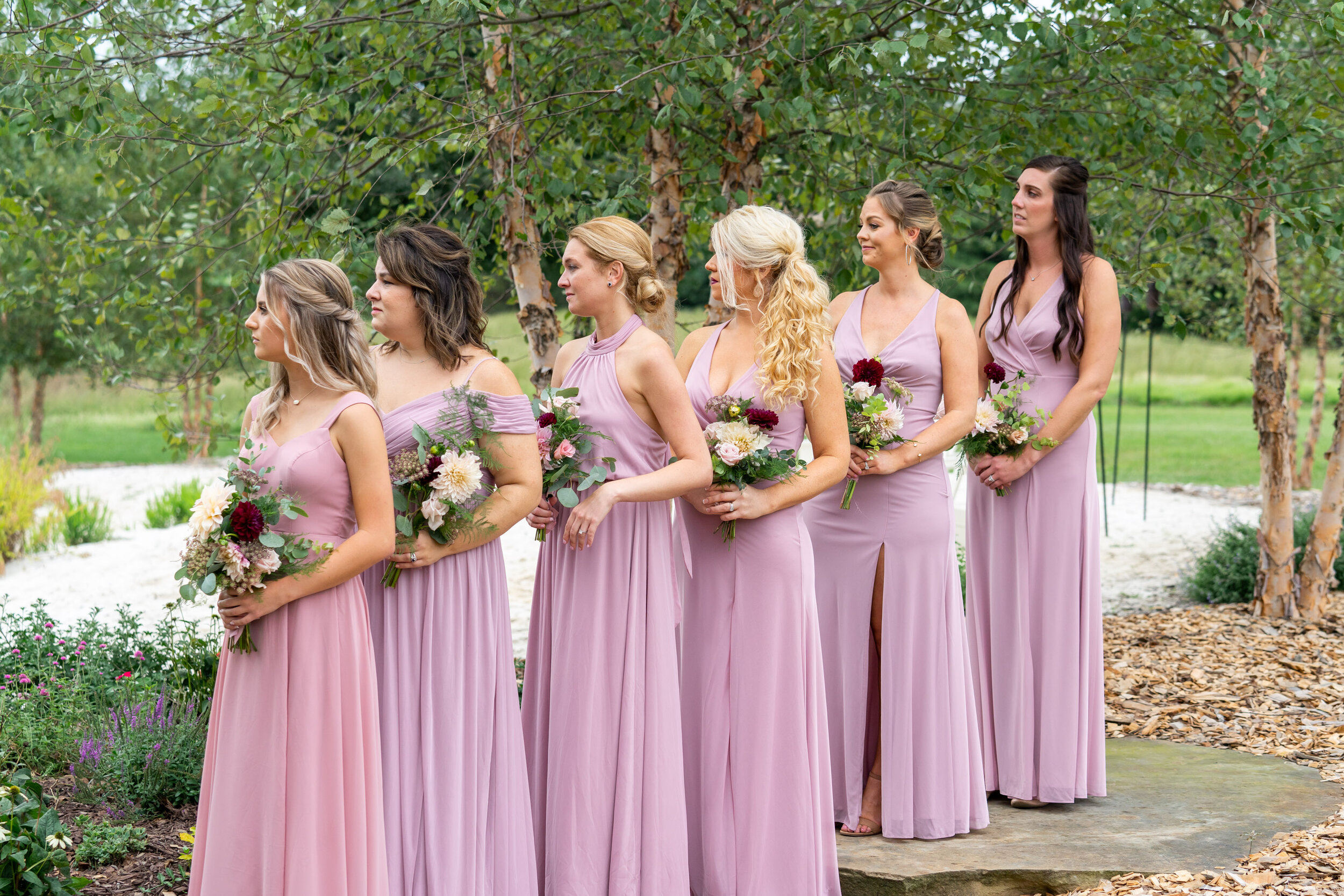 Bridesmaids in pink purple azazie dresses at ceremony at Glen Ellen Farm