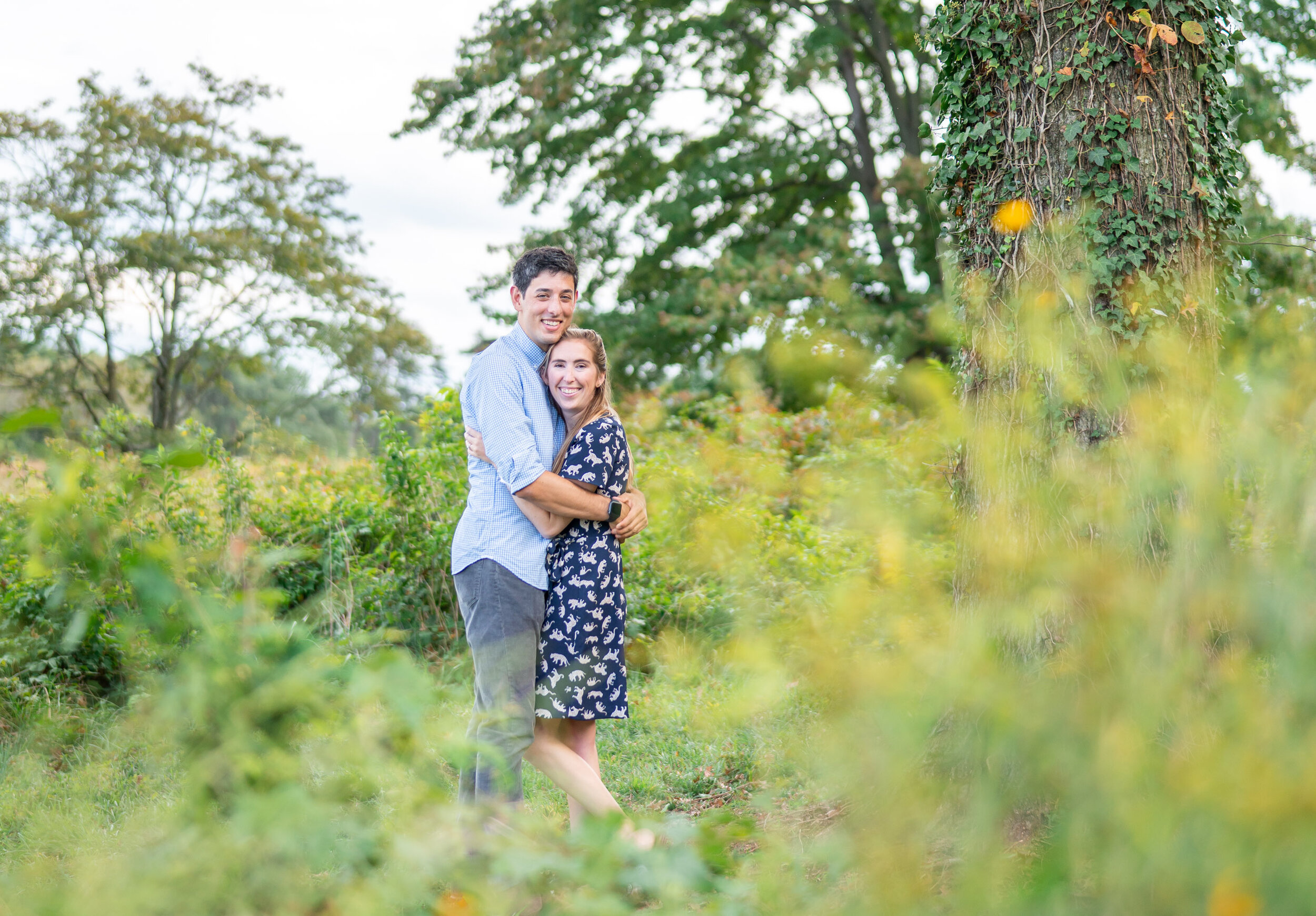 Couple hugging under trees in daisy black eyed susan field