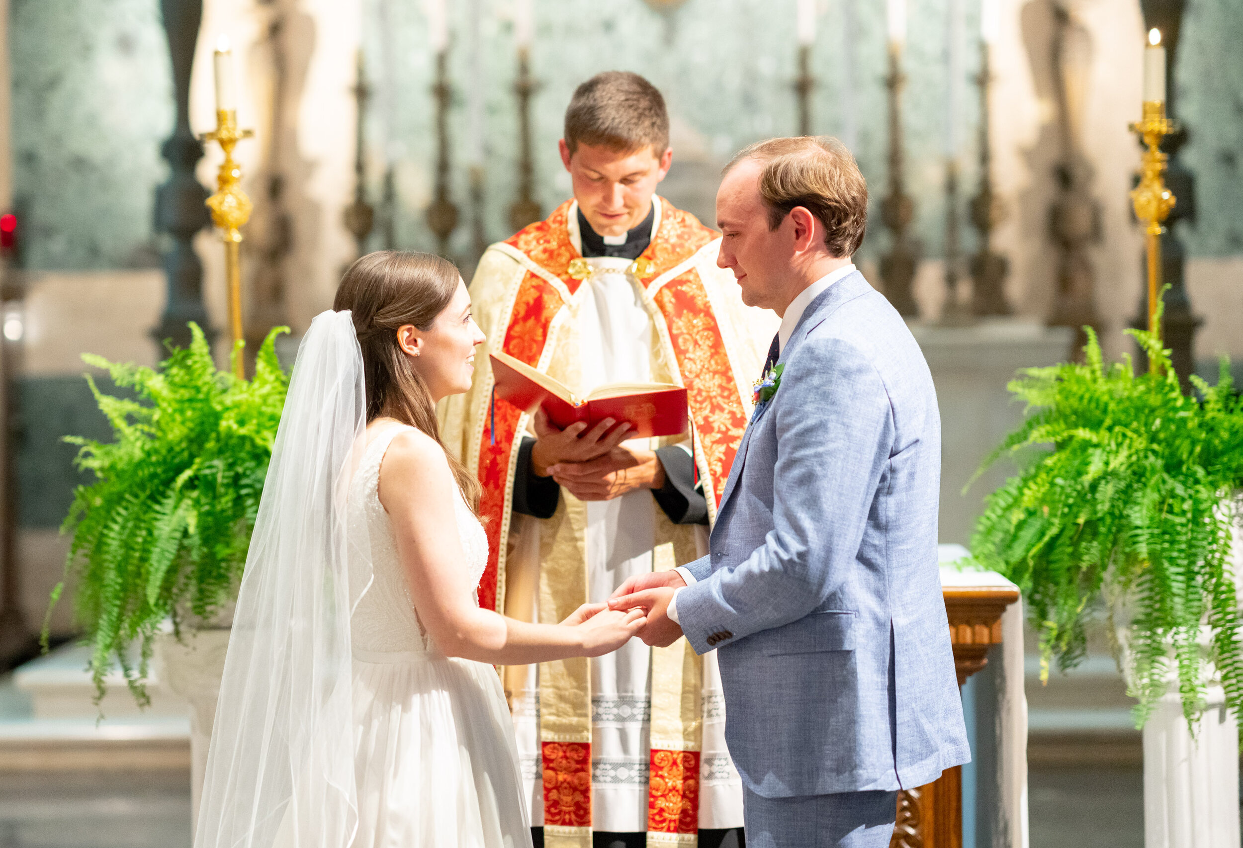 Bride and groom exchange vows in front of priest at Georgetown Prep School