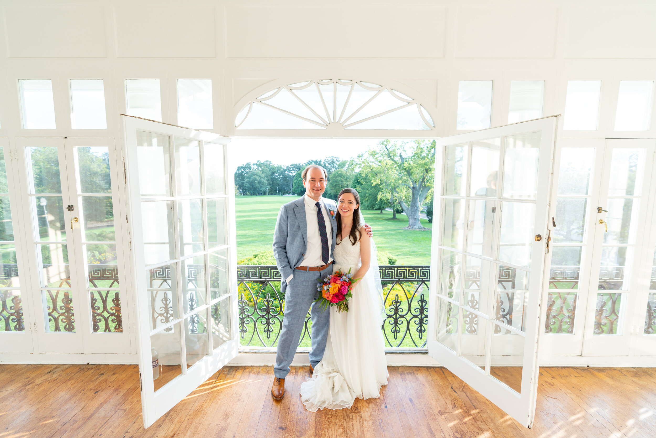 Bride and groom look out over lawn at Glenview Mansion in Rockville maryland