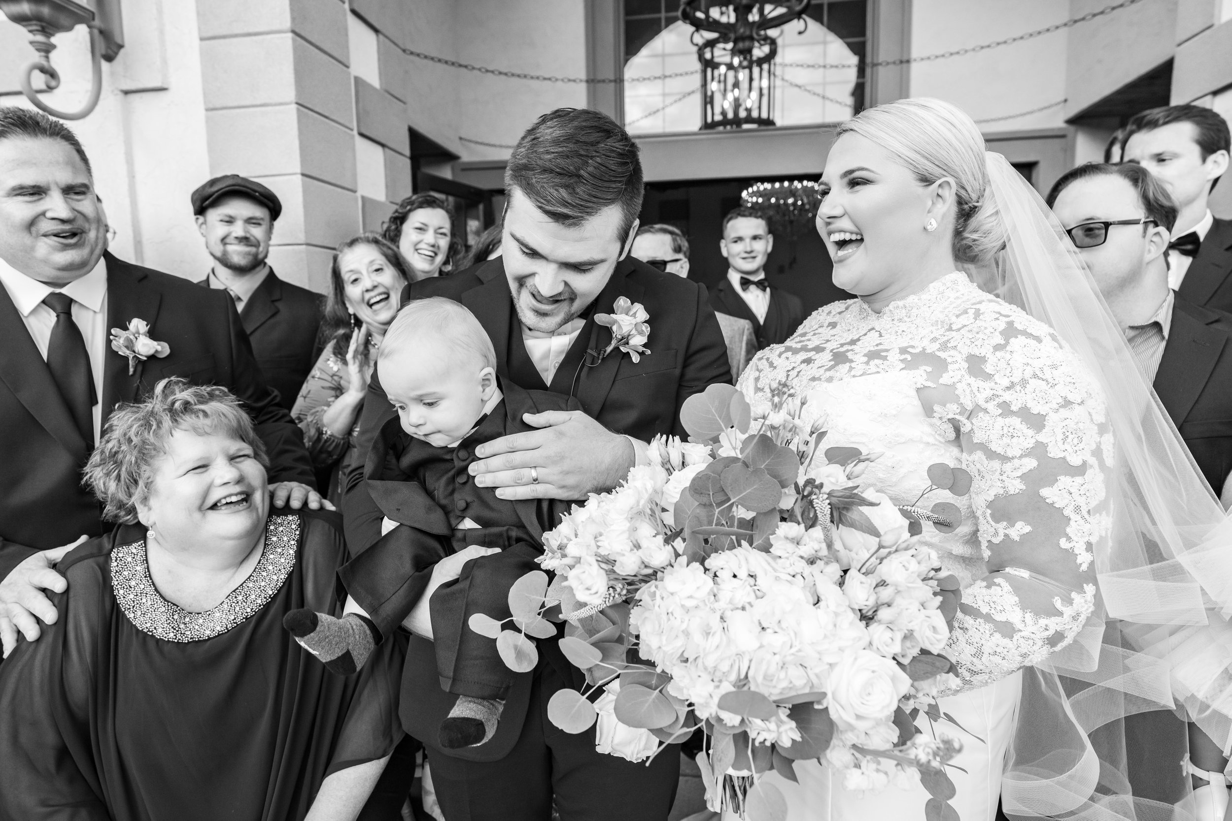 bride and groom hold their baby during family photos