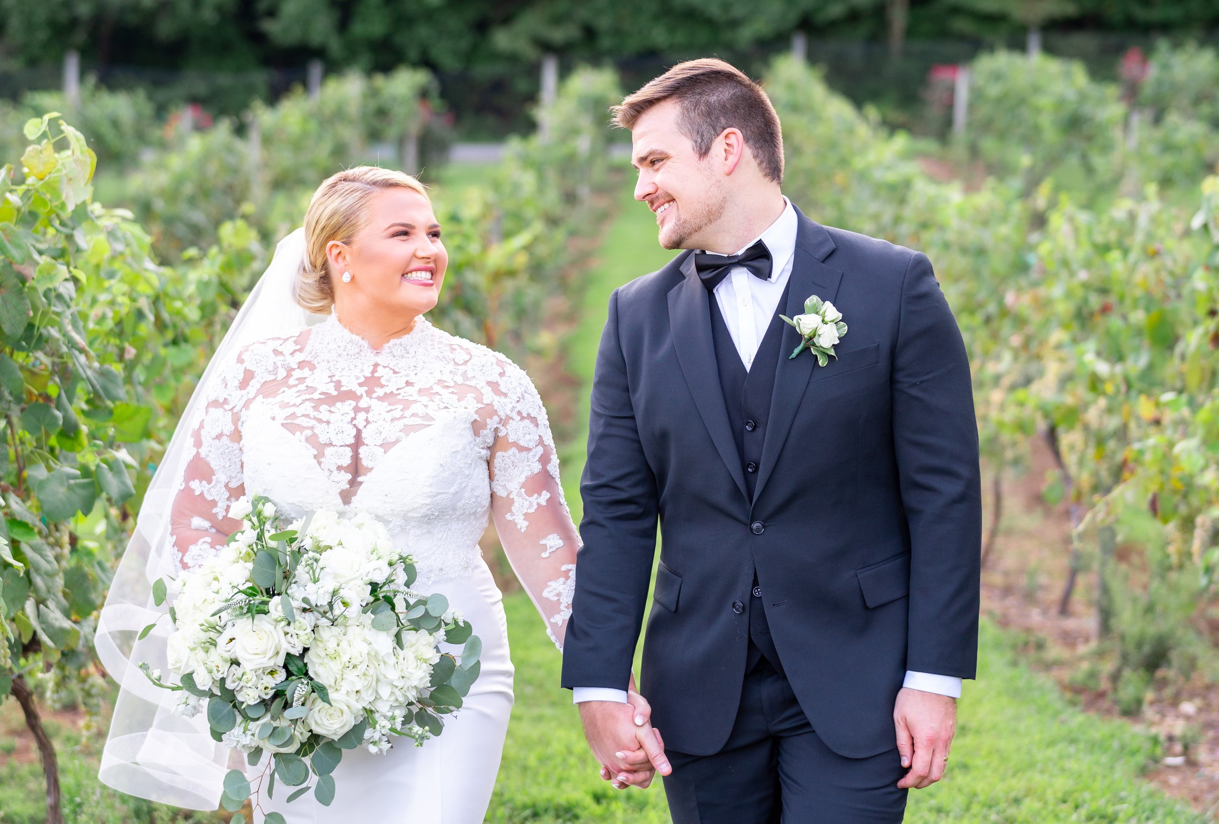 Bride and groom walk in maryland vineyard wedding venue holding hands