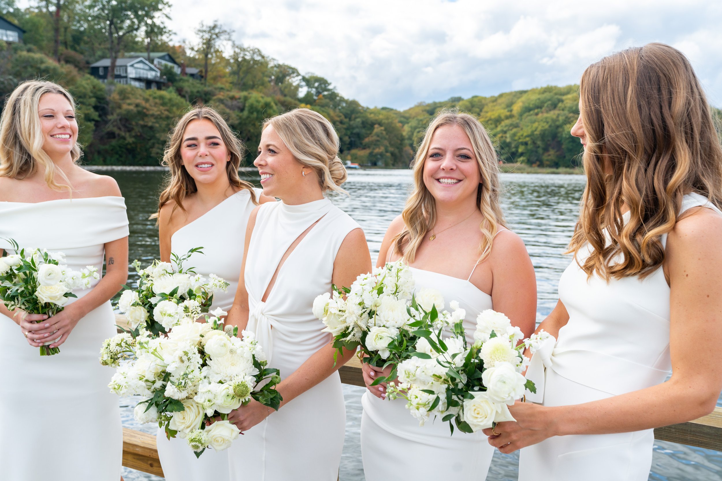 Bride smiles with bridesmaids all wearing white