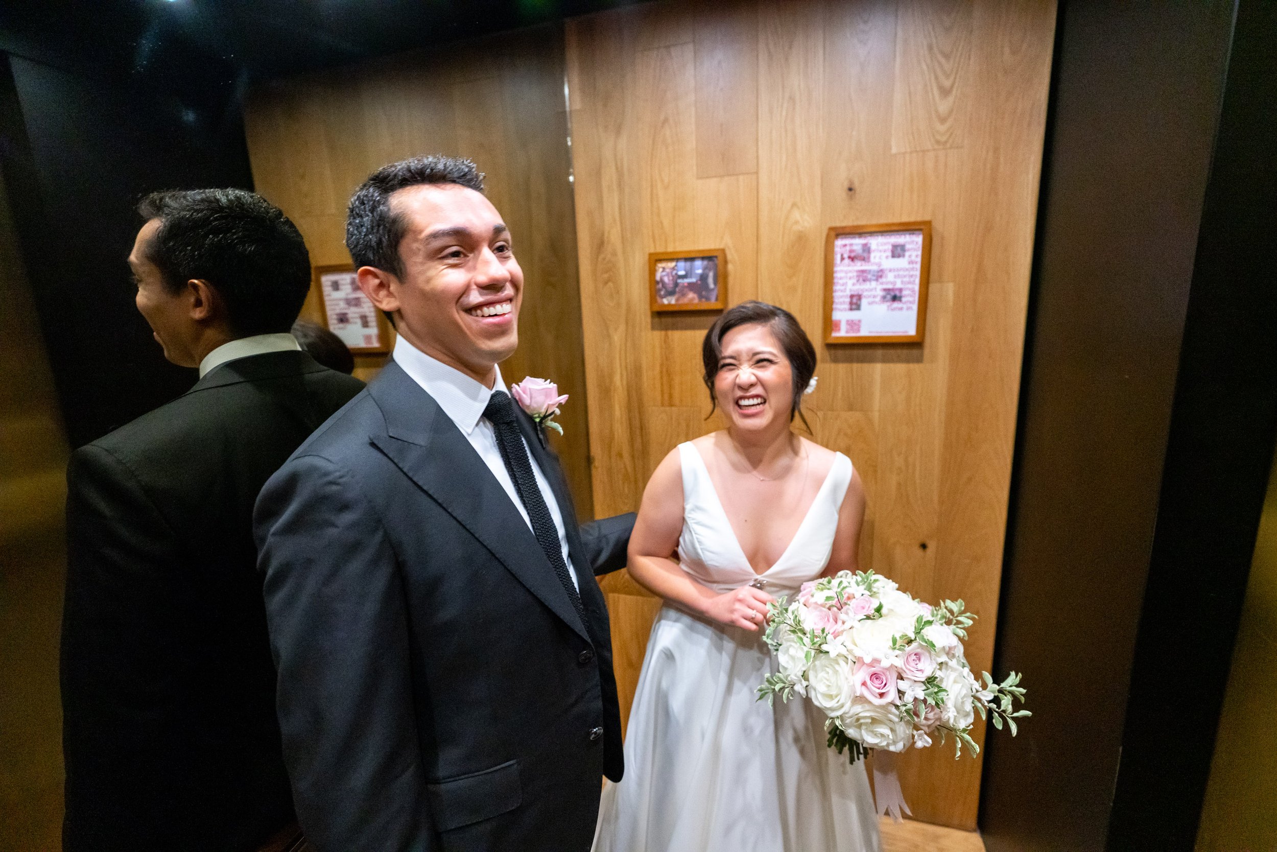 Bride and groom laughing in an elevator after the wedding ceremony