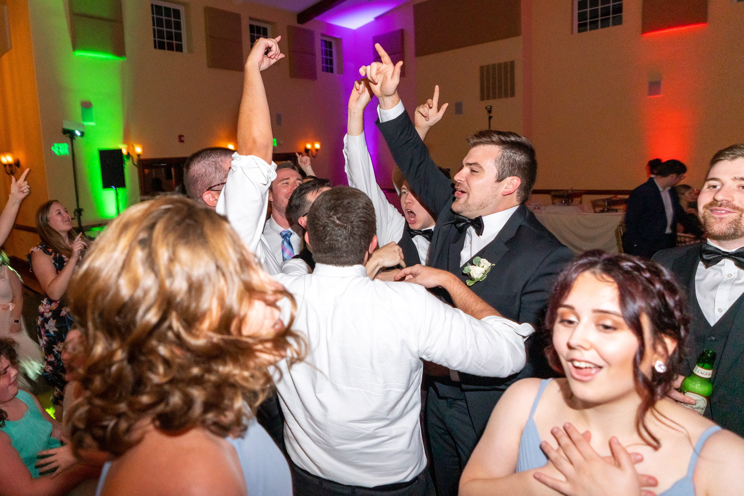 Groom and groomsmen jumping on the dance floor