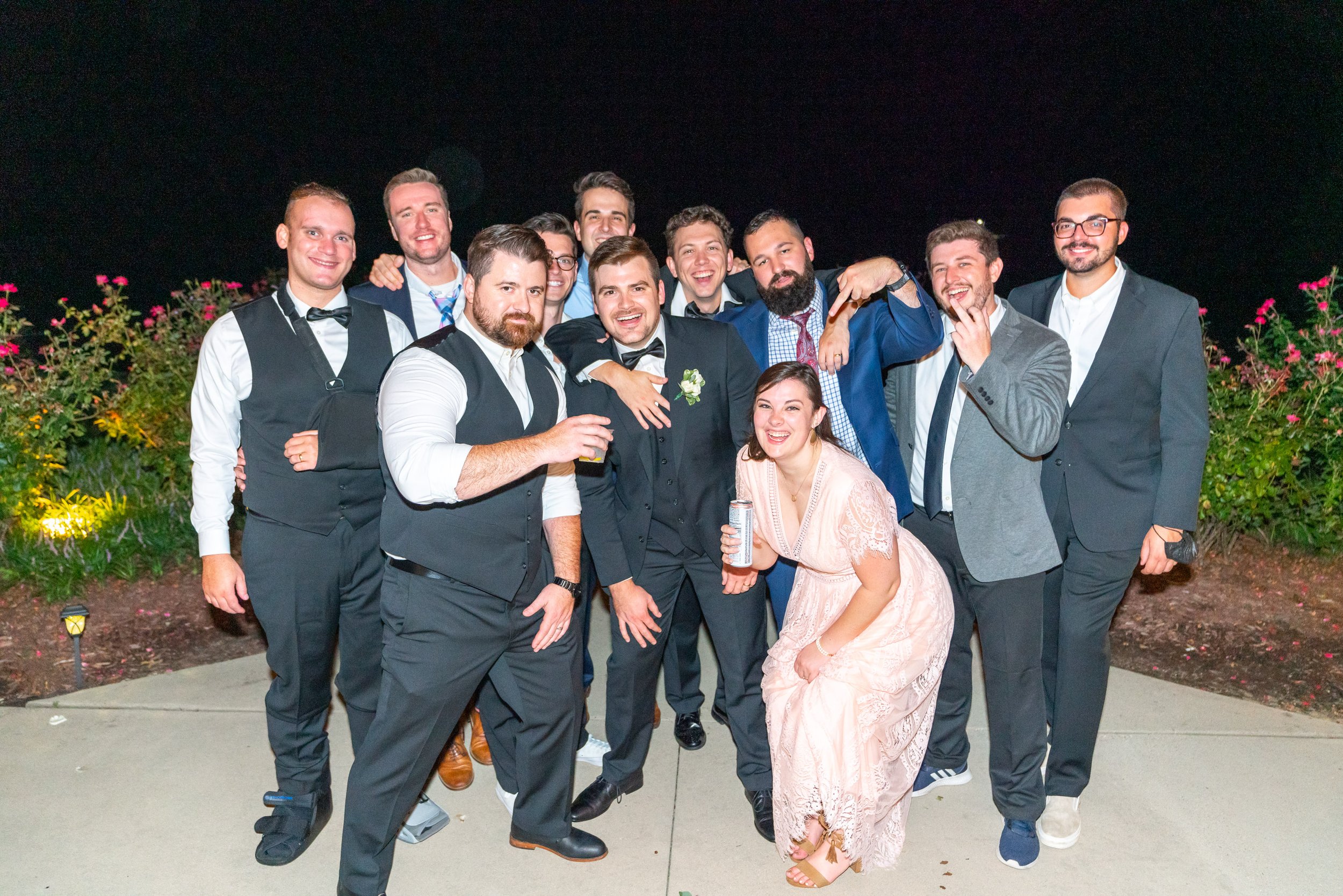 Groom and groomsmen pose for a group photo at night at running hare vineyard