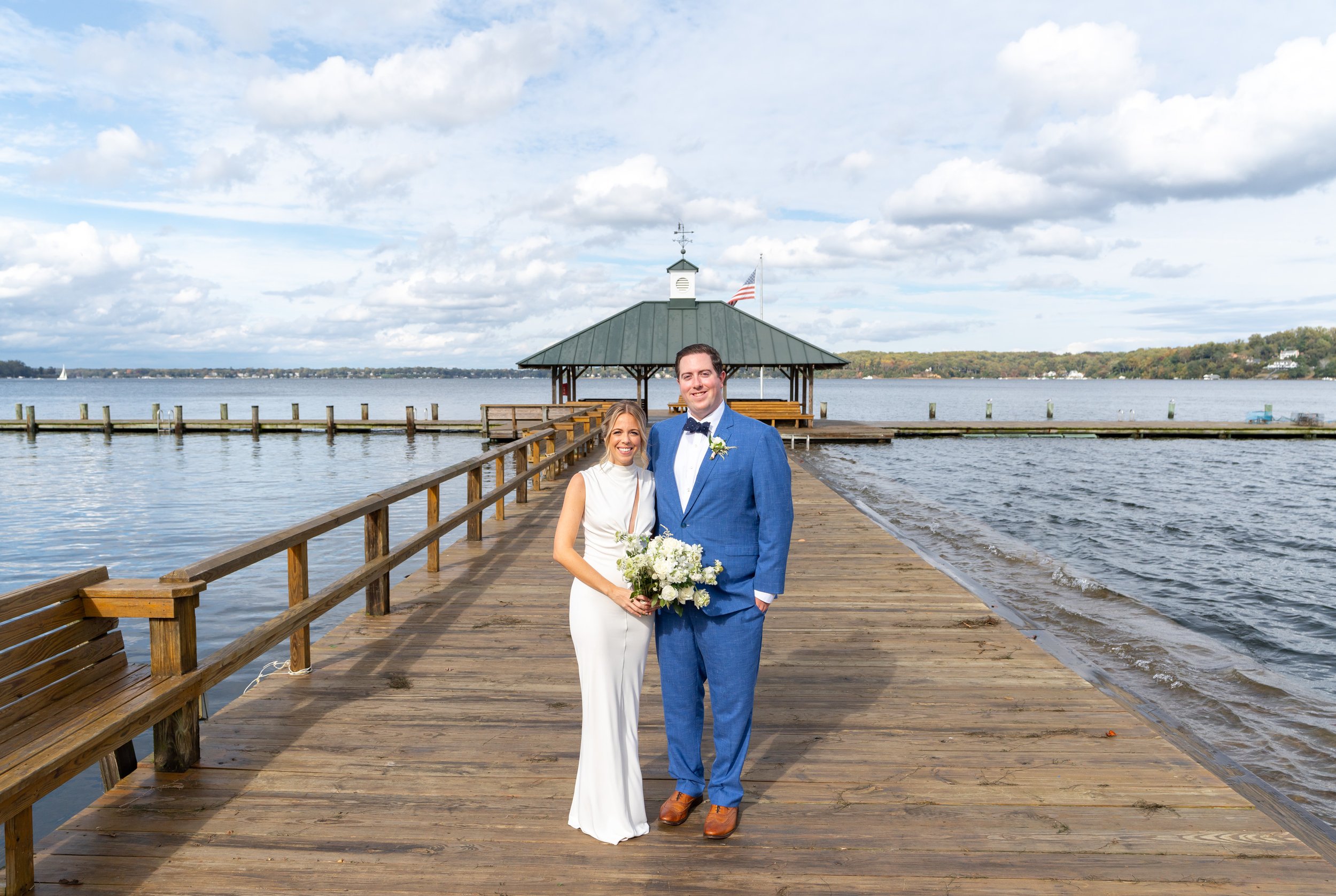 Bride and groom pose on dock at ocean beachfront wedding in Sherwood Forest